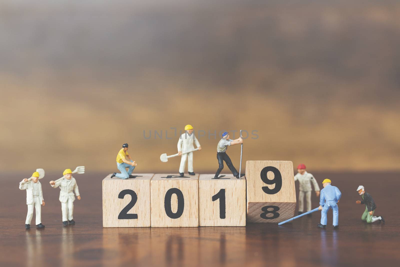 Miniature worker team building wooden block number 2019 on wooden background

