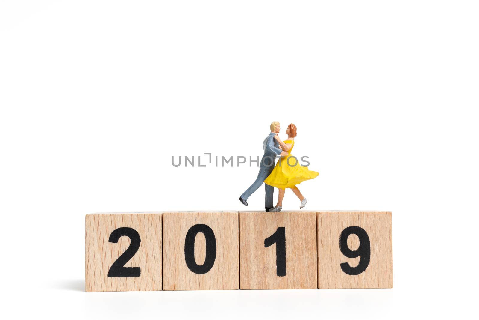 Miniature people dancing on wooden block number 2019. on white background