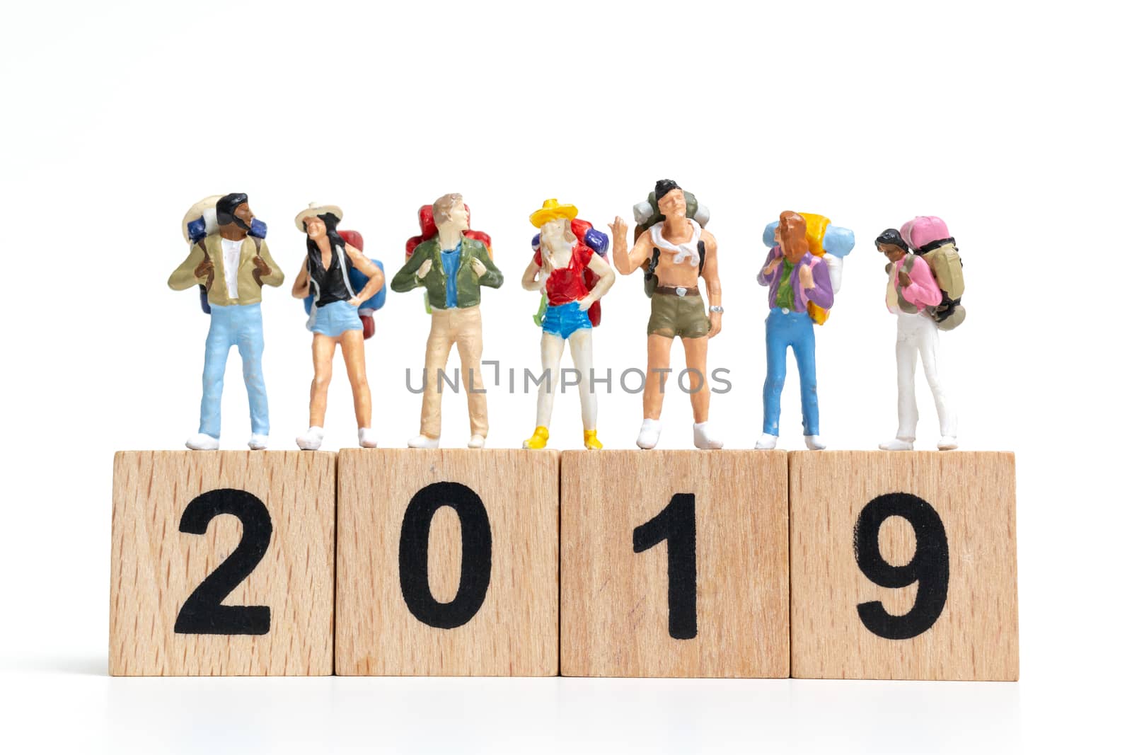 Miniature people Backpacker  on wooden block number 2019. isolated on white background