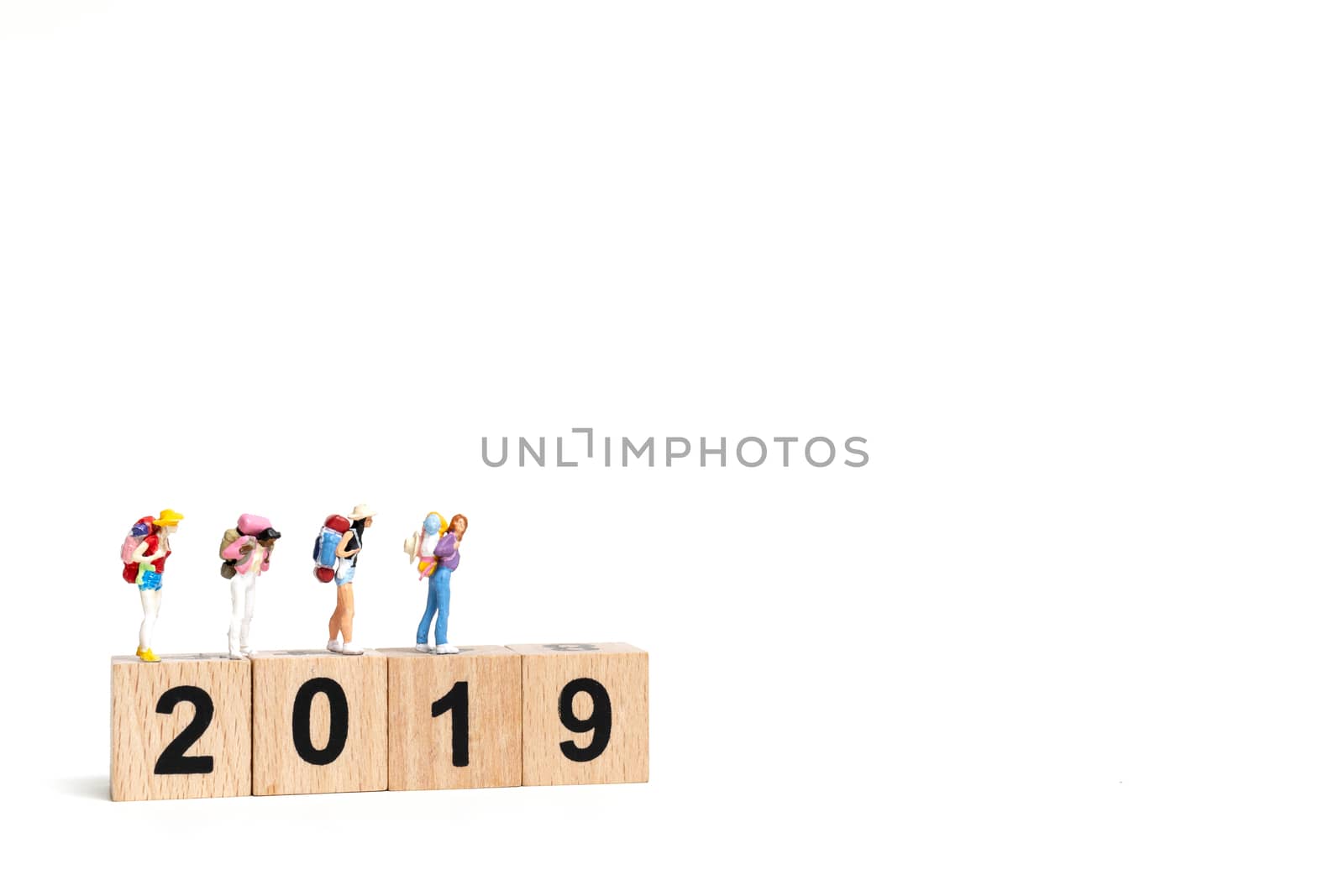 Miniature people Backpacker  on wooden block number 2019. isolated on white background