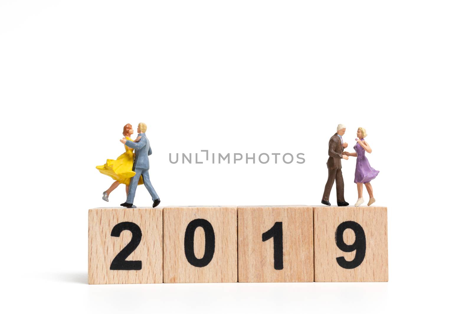 Miniature people dancing on wooden block number 2019. on white background