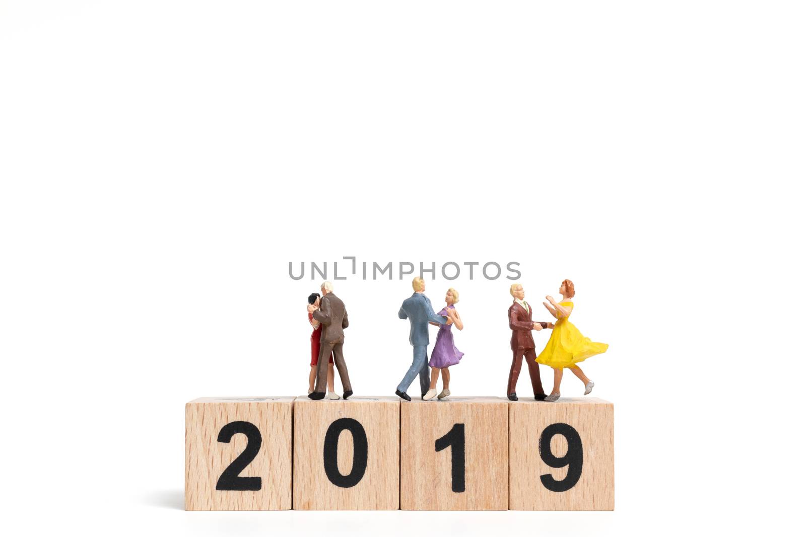 Miniature people dancing on wooden block number 2019. on white background