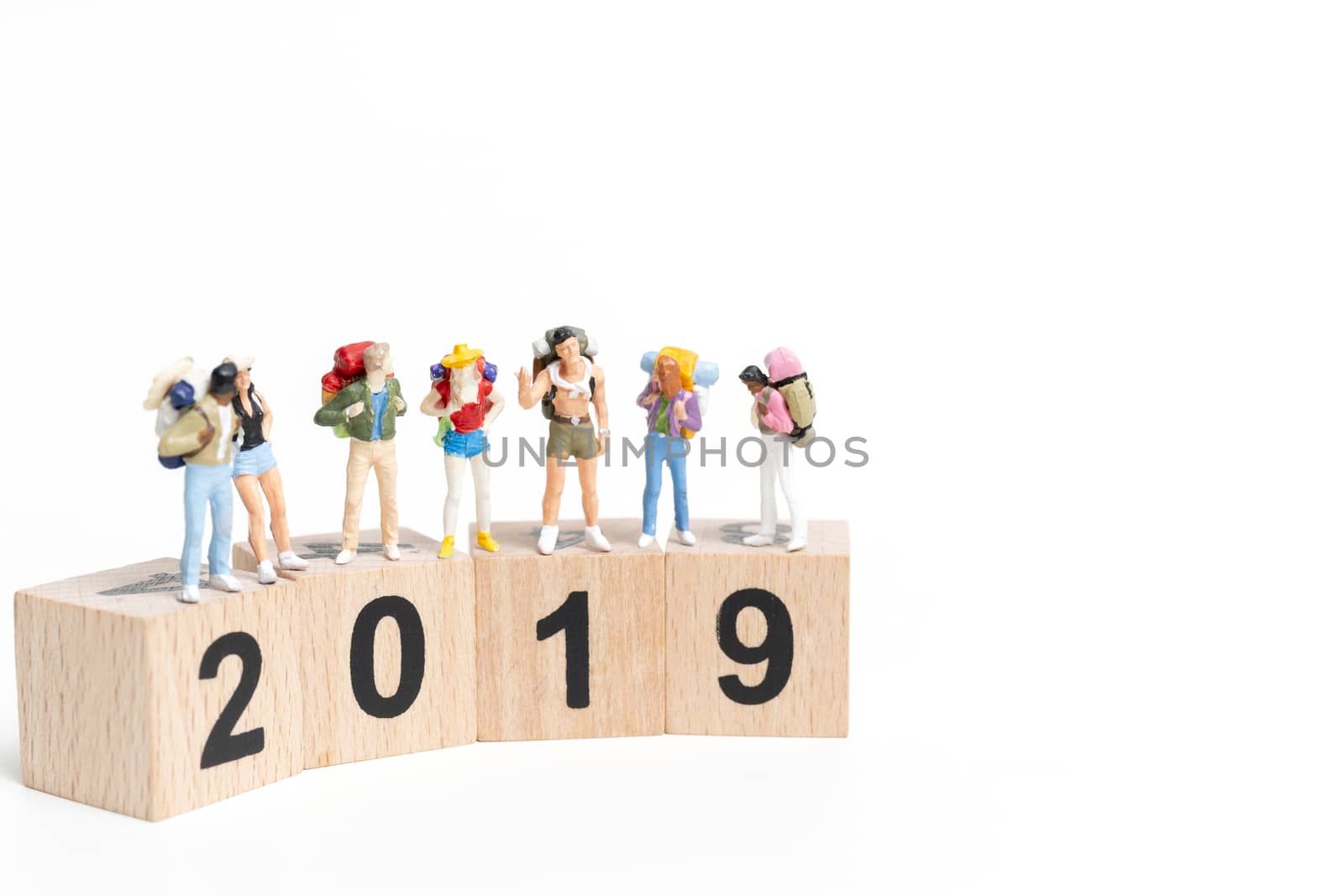 Miniature people Backpacker  on wooden block number 2019. isolated on white background