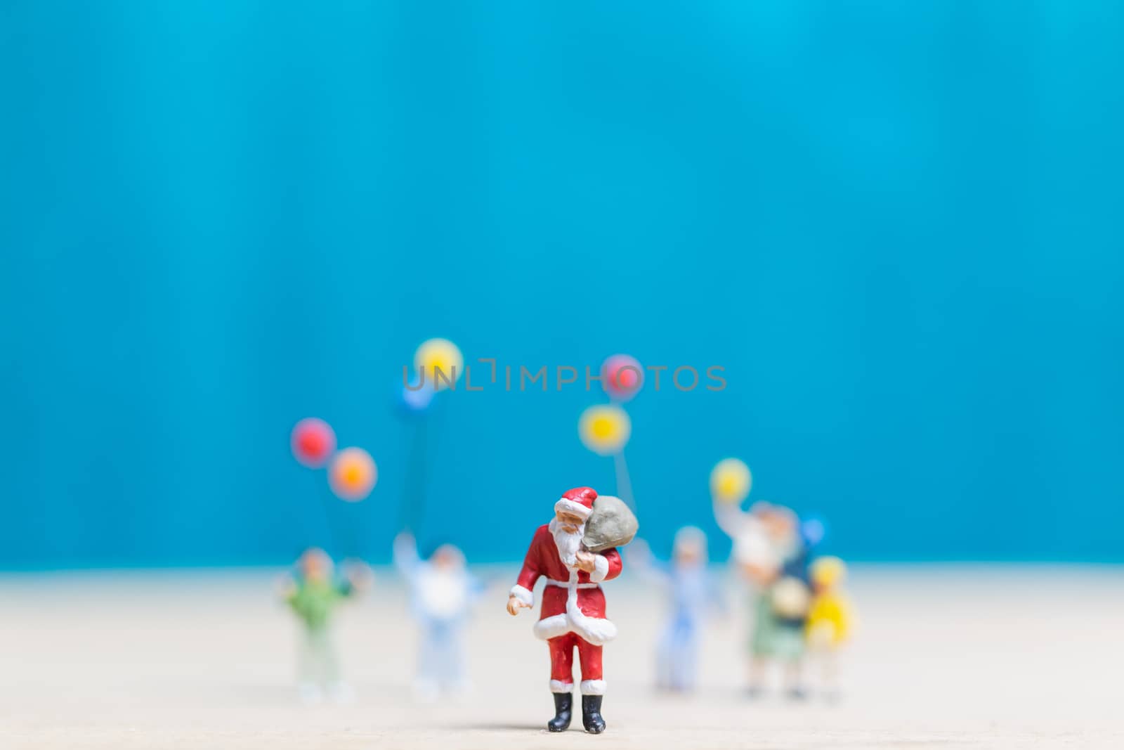 Miniature people: Santa Claus and children holding balloon , Merry Christmas and Happy New Year concept.