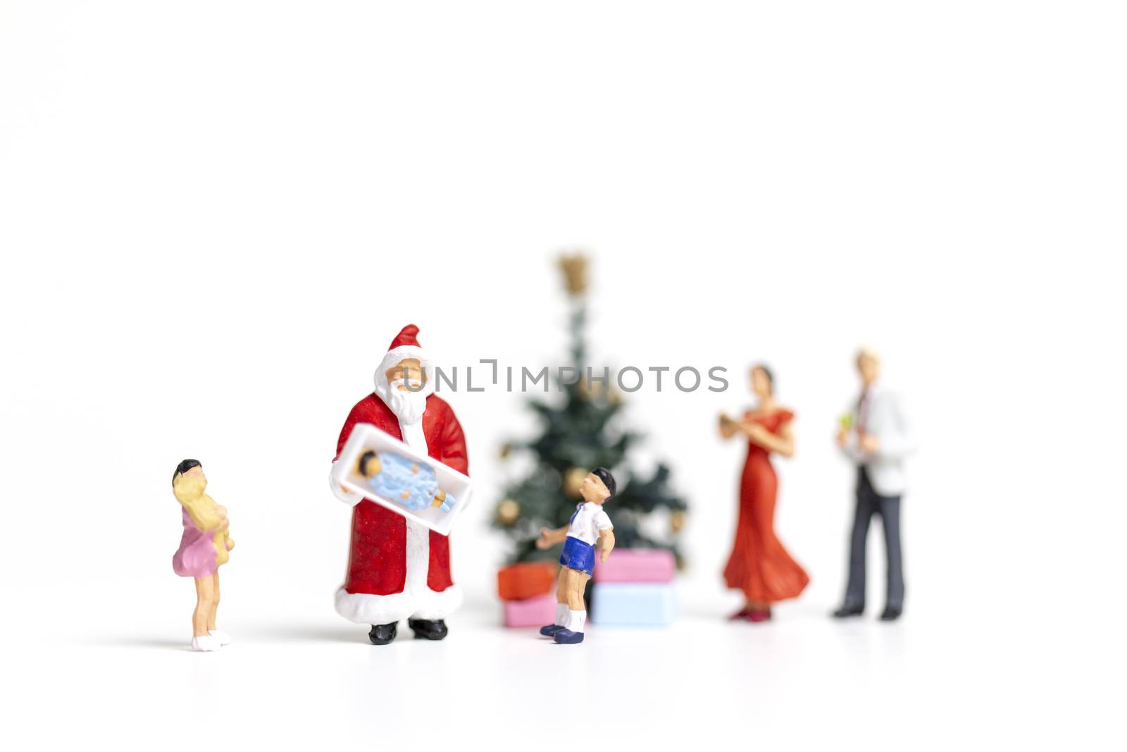 Miniature people : Santa Claus holding gift for happy family , Christmas and Happy New Year concept.