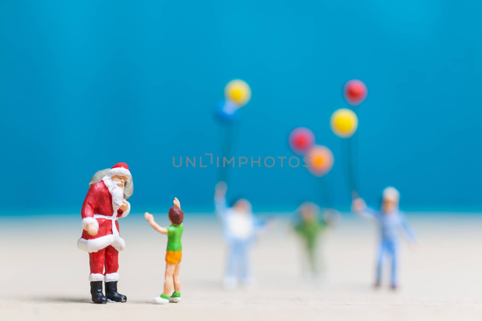 Miniature people: Santa Claus and children holding balloon , Merry Christmas and Happy New Year concept.