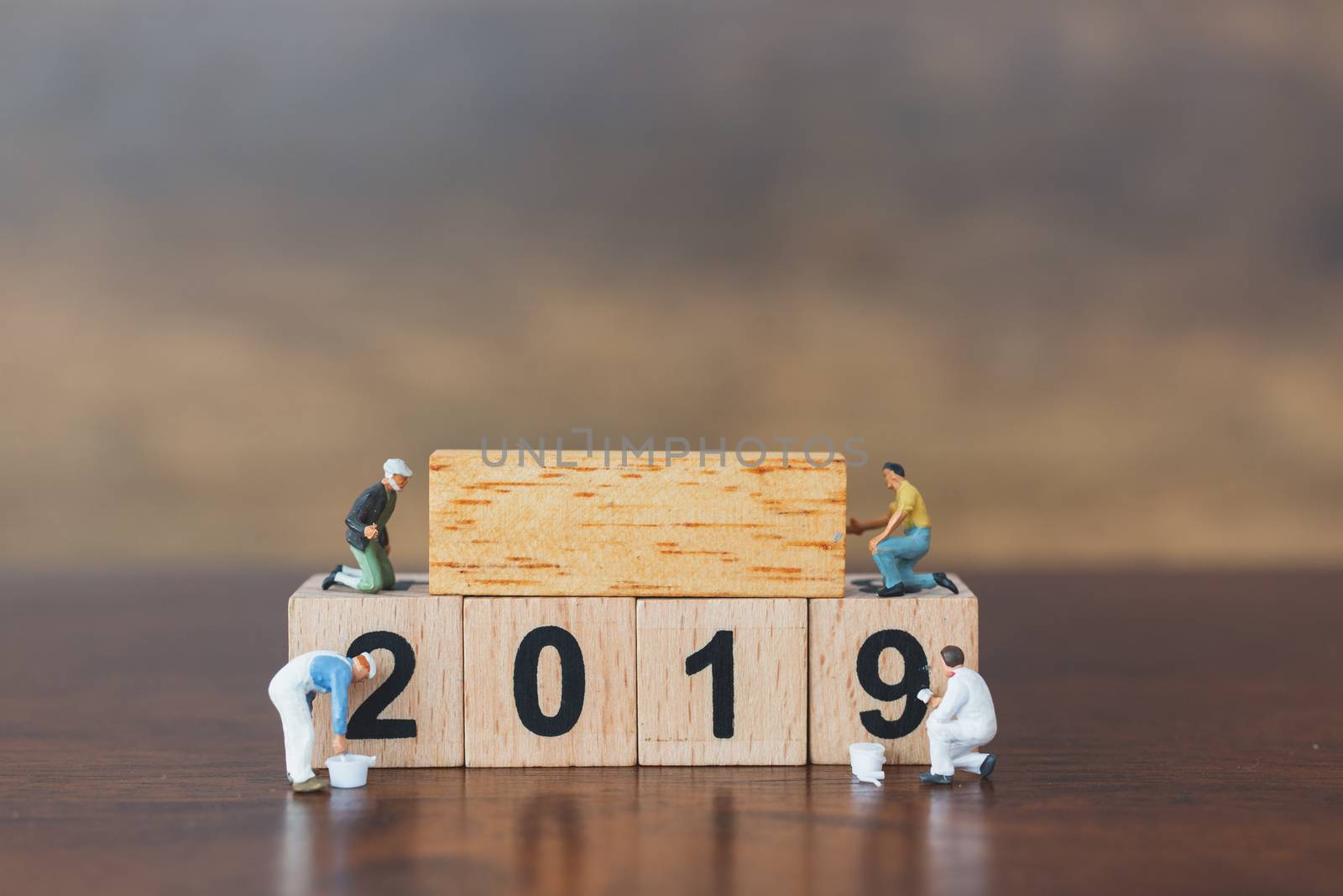 Miniature worker team painting  on wooden block , Happy new year 2019 concept