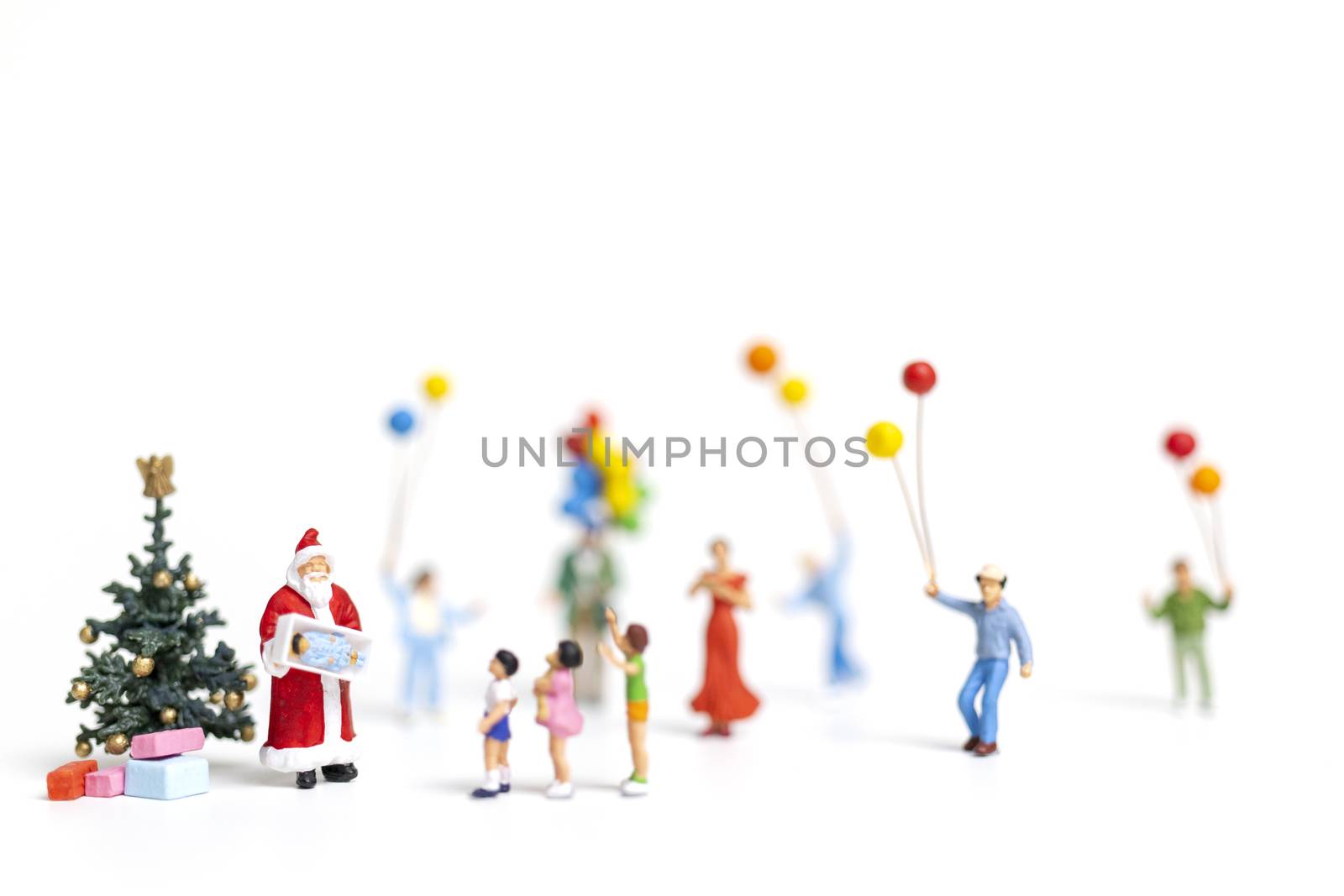 Miniature people : Santa Claus holding gift for happy family , Christmas and Happy New Year concept.