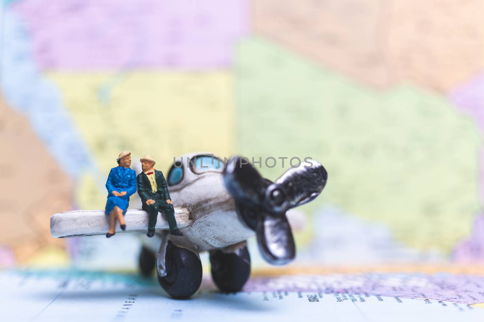 Miniature people sitting on The Airplane with world map background, Travel concept