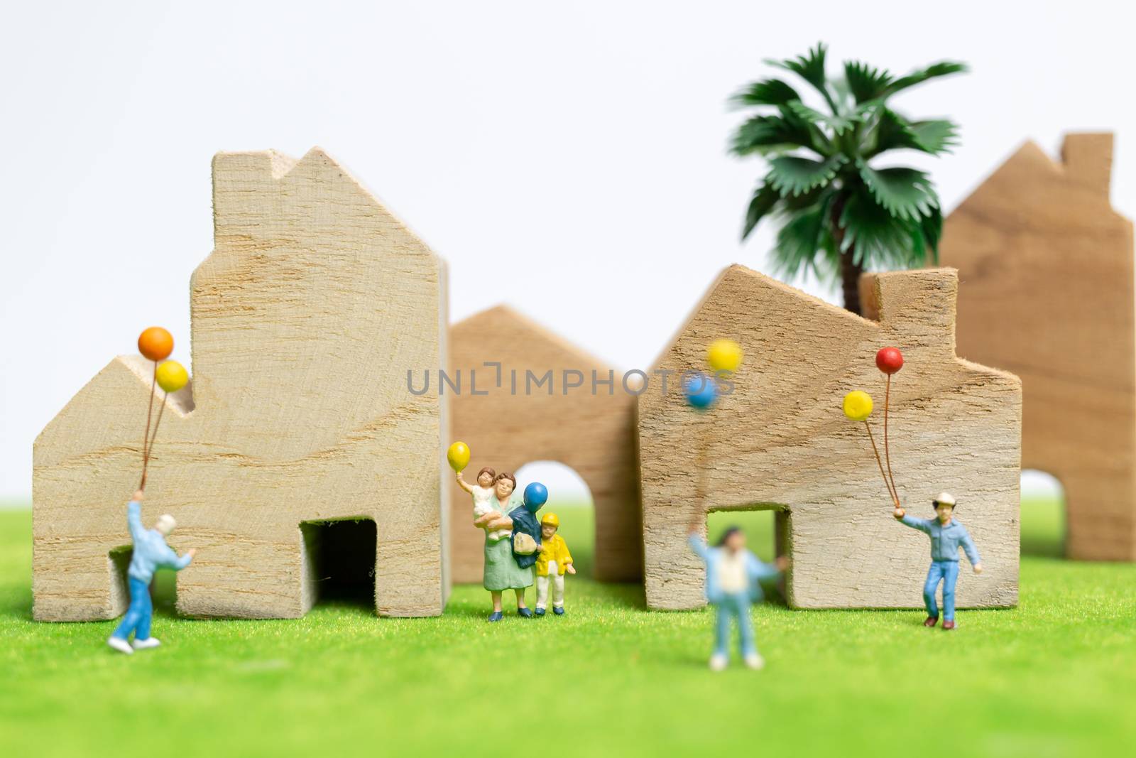 Miniature people : Happy family walking in field with balloons ,   Happy family relations and carefree leisure time Concept