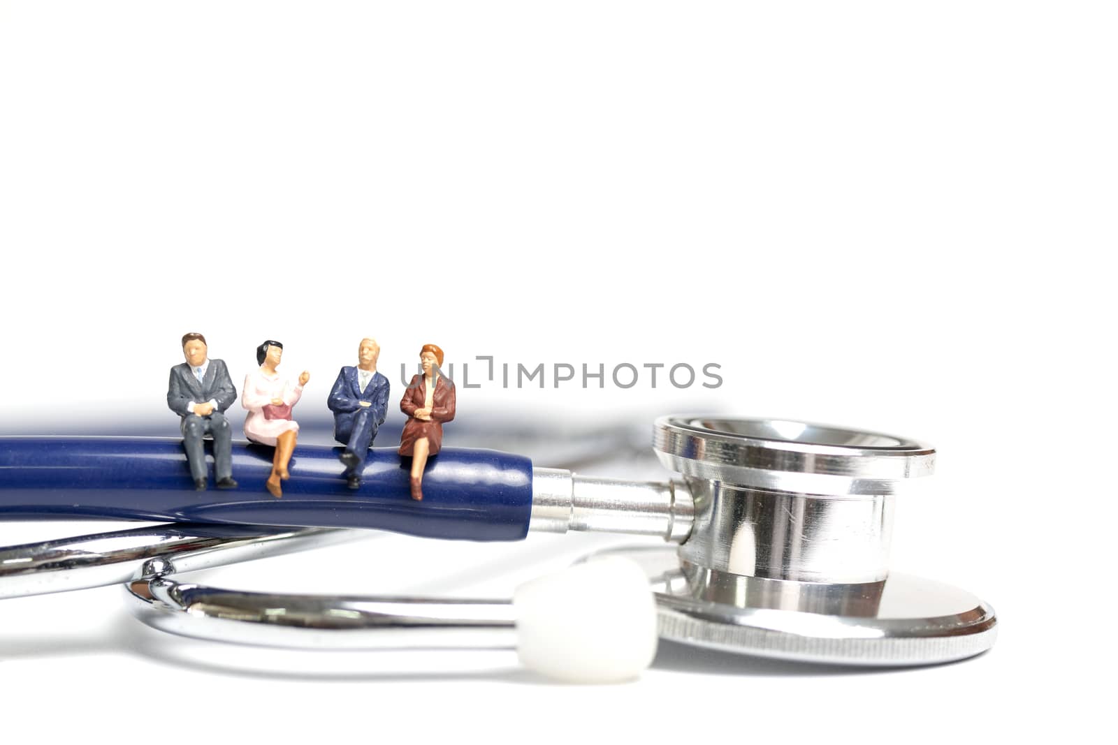 Miniature people sitting on a stethoscope on white background , Health care  concept