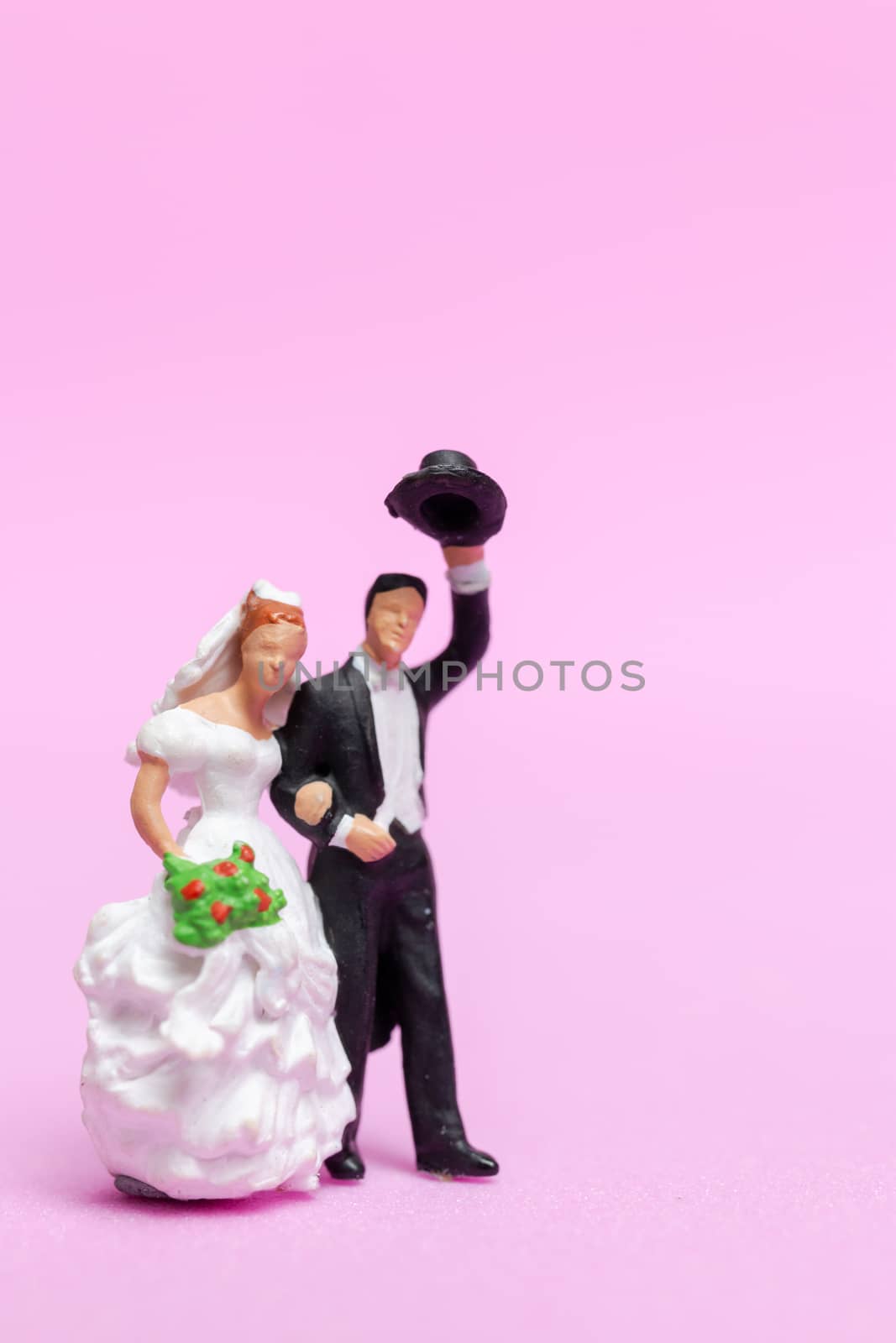 Miniature people wedding , bride and groom couple on pink  background , Valentine's Day concept