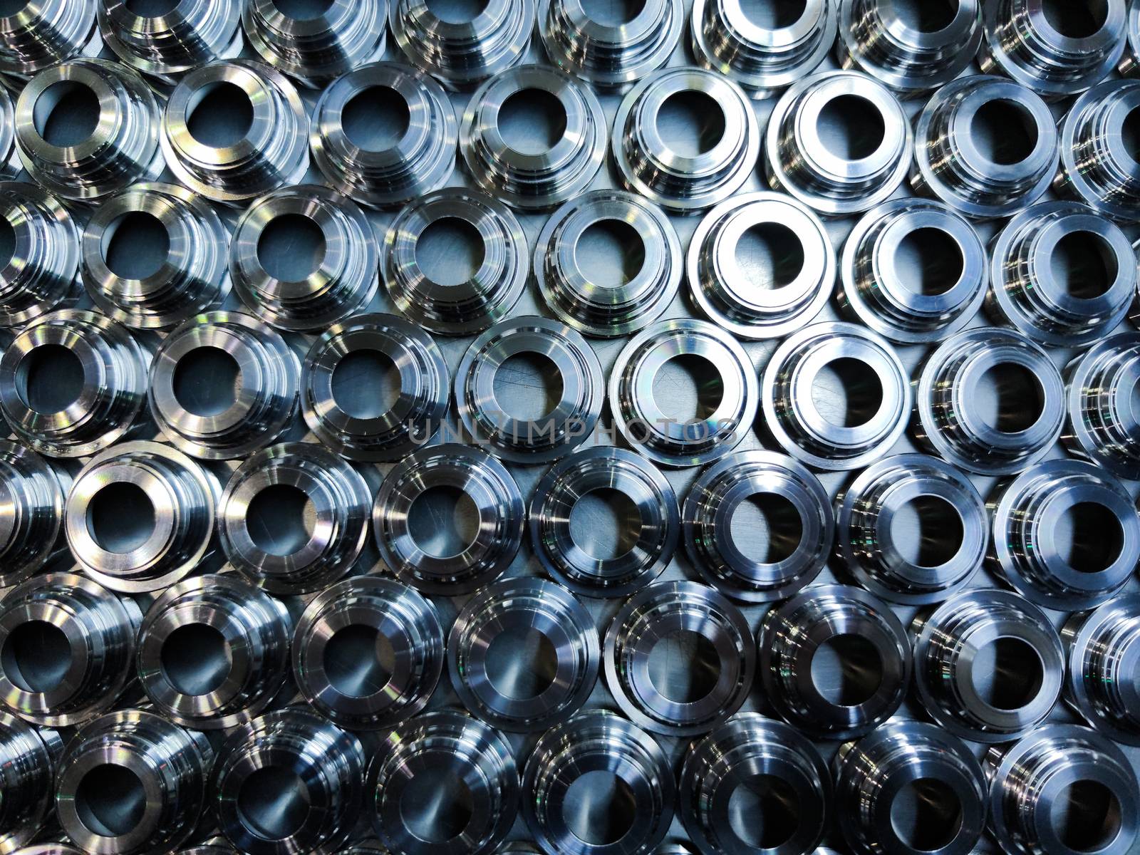 a batch of shiny metal cnc aerospace parts production - close-up with selective focus for industrial background in flat lay composition