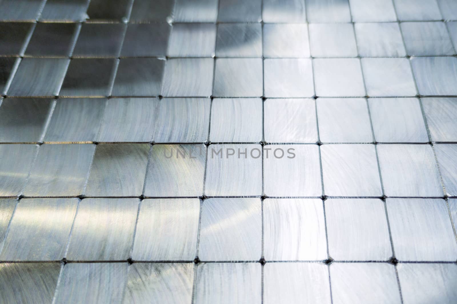 shiny steel machined blocks pavement surface background - close-up with selective focus and blur.