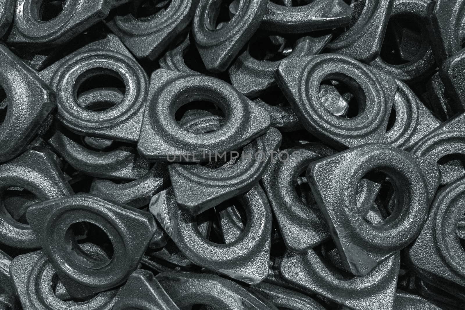 heap of grey steel forgings after shot blasting - close-up natural heavy industrial pattern with selective focus and grim mood