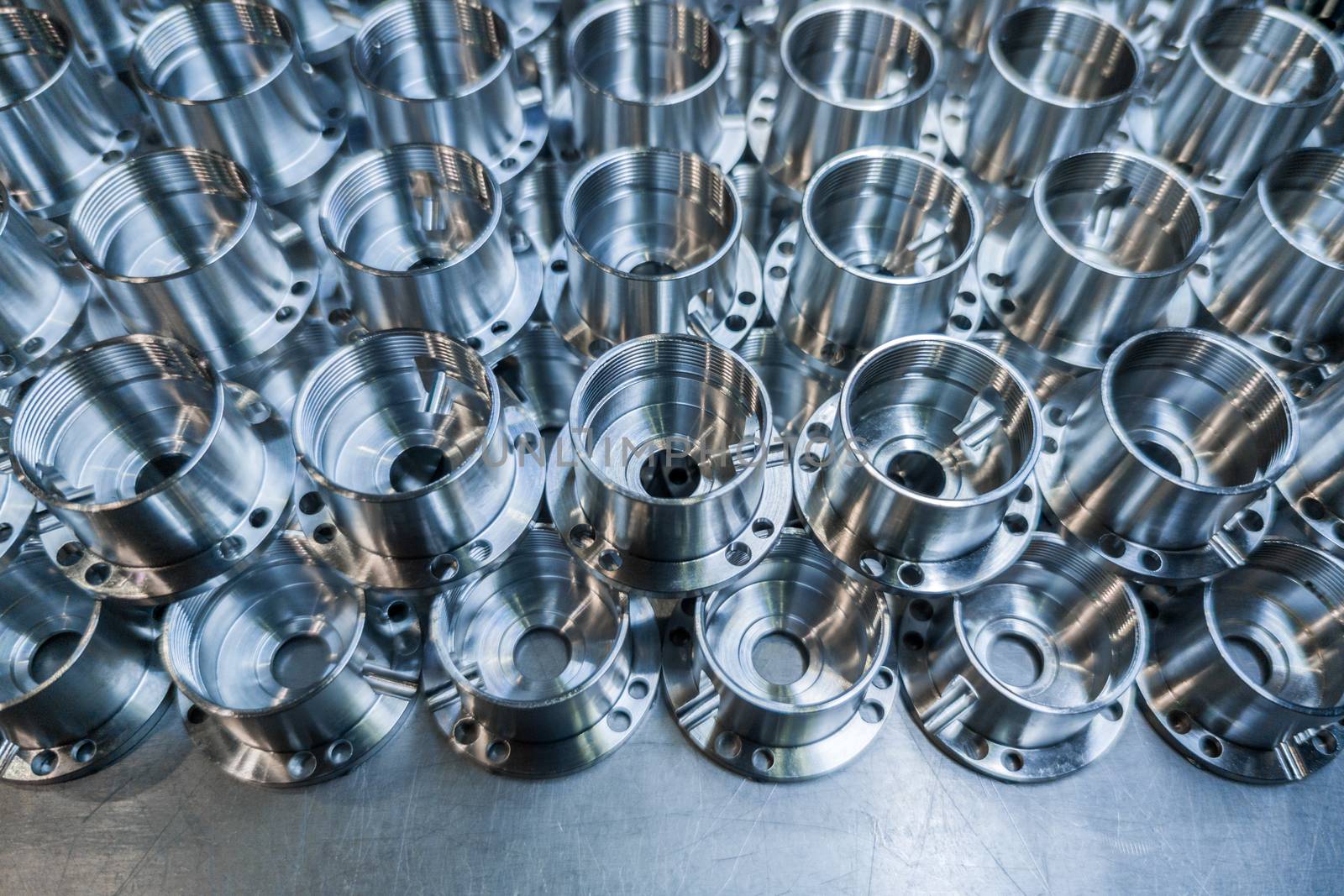 a batch of shiny metal aerospace parts production made with cnc machines - close-up with selective focus for industrial background