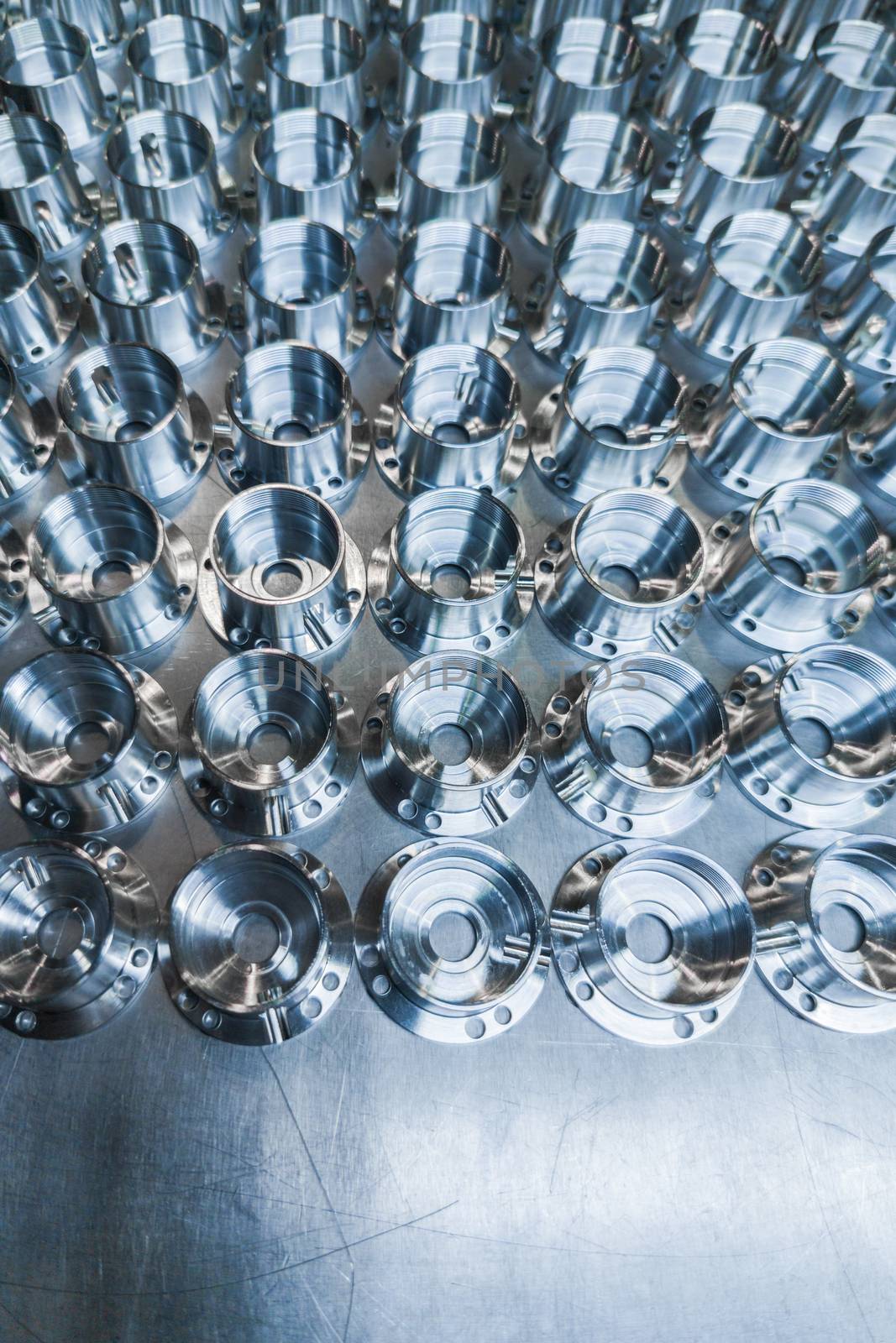 a batch of shiny metal cnc aerospace parts production - close-up with selective focus for industrial background by z1b