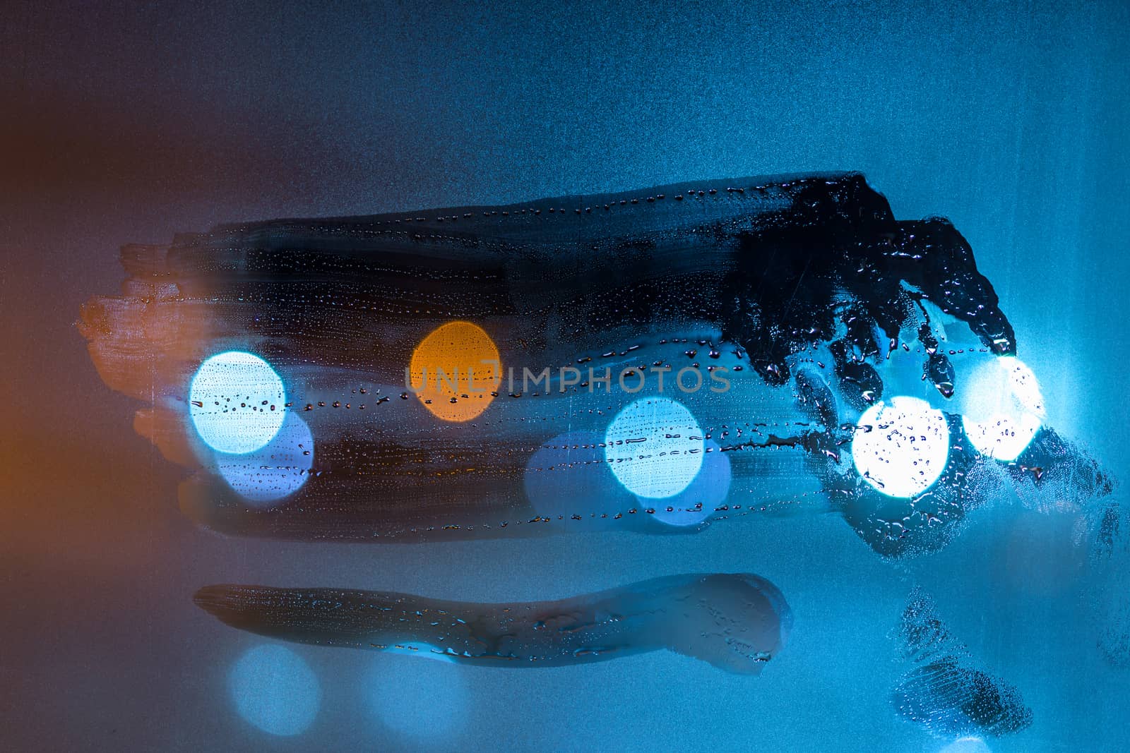 a night wet window glass wiped by hand - dark background and mockup.