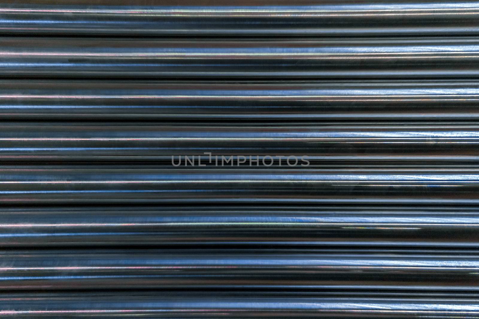 abstract industrial background of shiny cnc turned rods with flat lay in simple horizontal parallel geometric pattern
