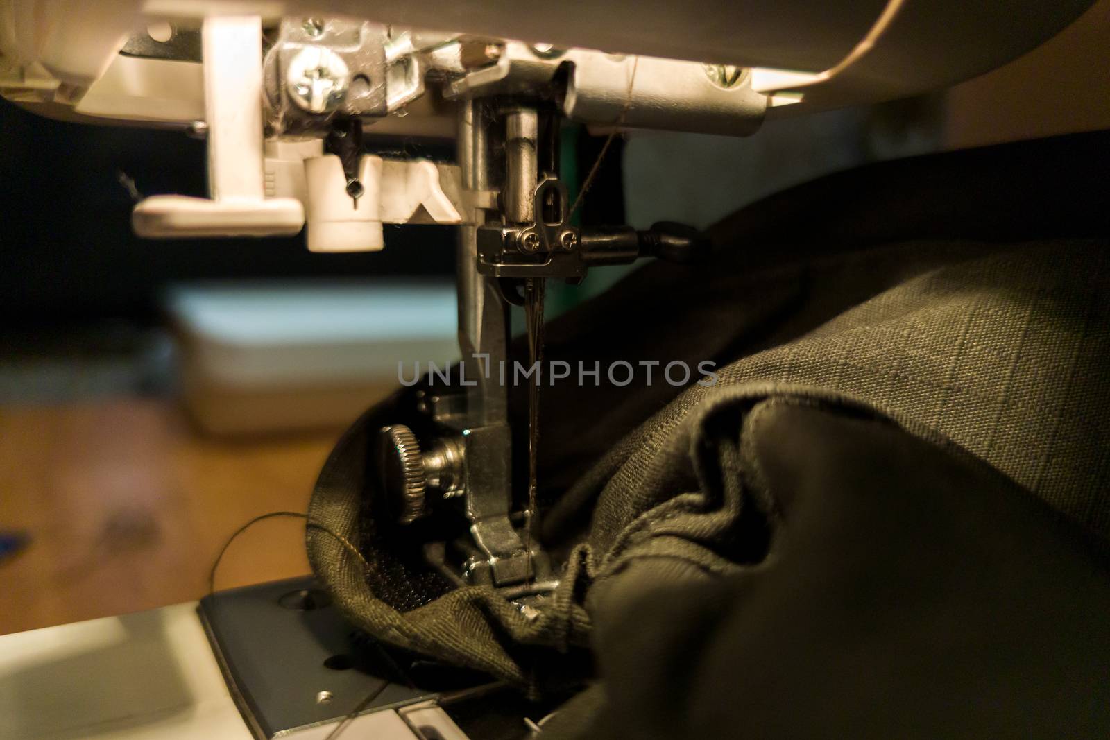 a dark gomestic sewing with machine and green military cloth.