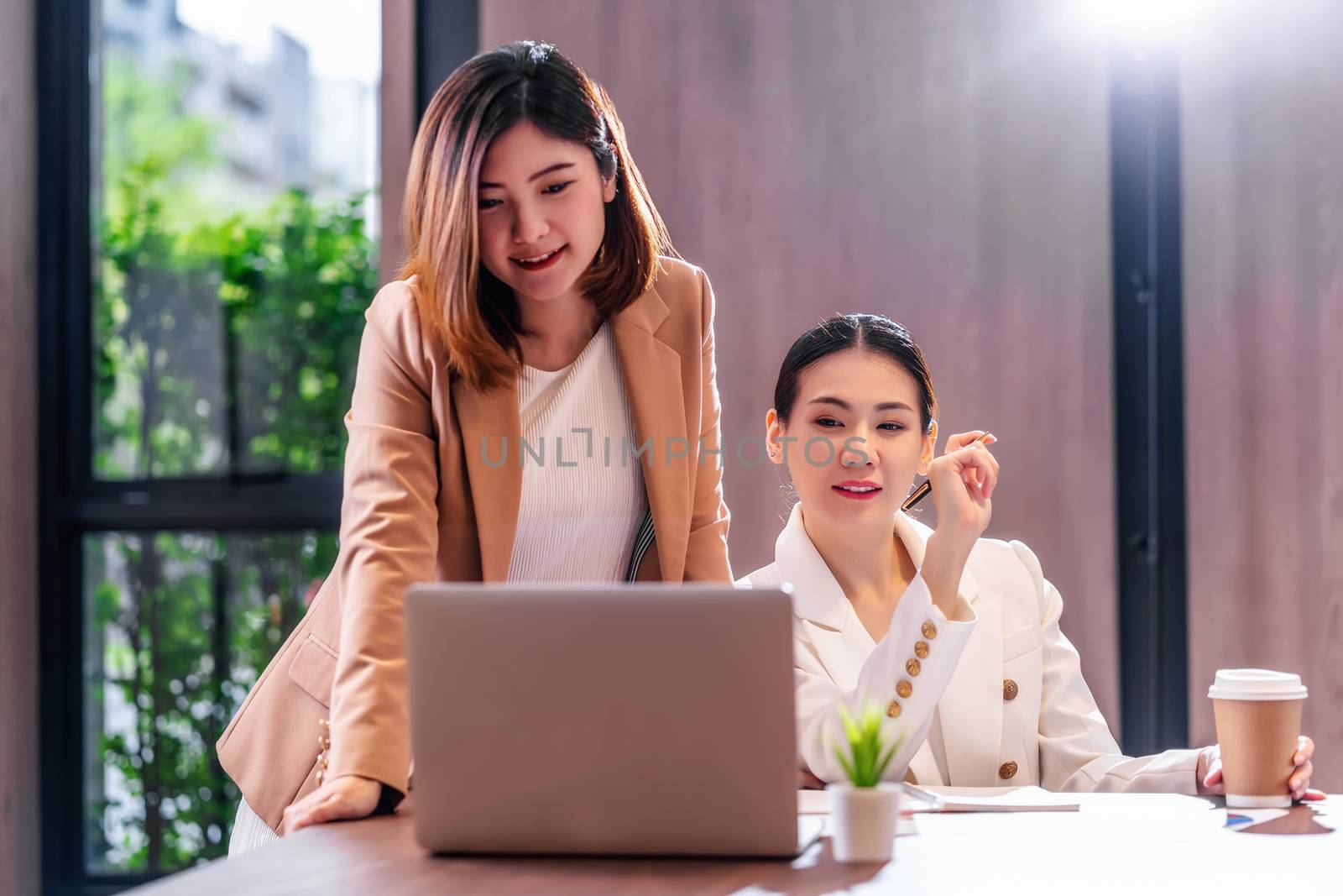 Two asian businesswomen working with the partner business via te by Tzido
