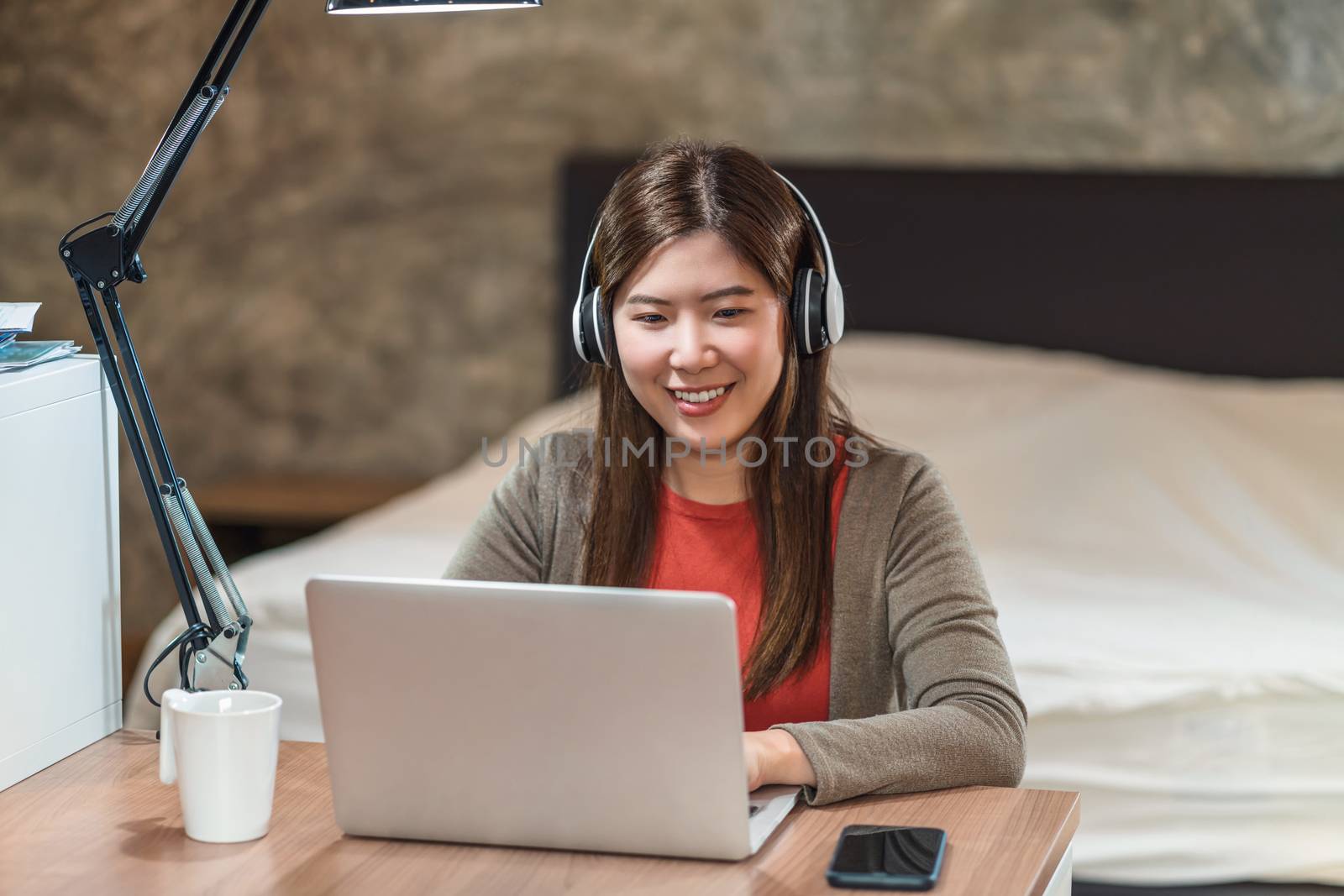 Asian business woman using technology laptop and working from home in bedroom,freelance and entrepreneur,startups and business owner,lifestyle occupation,social distancing and self responsibility