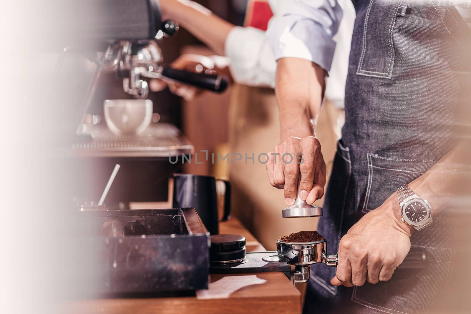Closeup Asian Barista tamping the portafilter and preparing cup of coffee, espresso with latte or cappuccino for customer order in coffee shop, Small business owner and startup in coffee shop concept