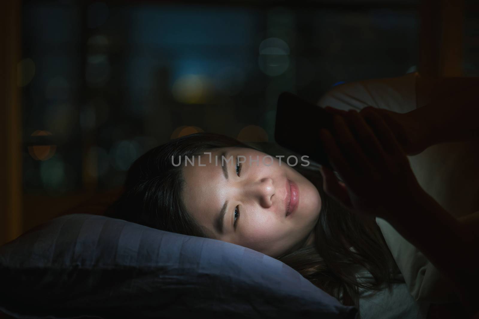 Asian woman sleeping and using smart mobile phone for social net by Tzido