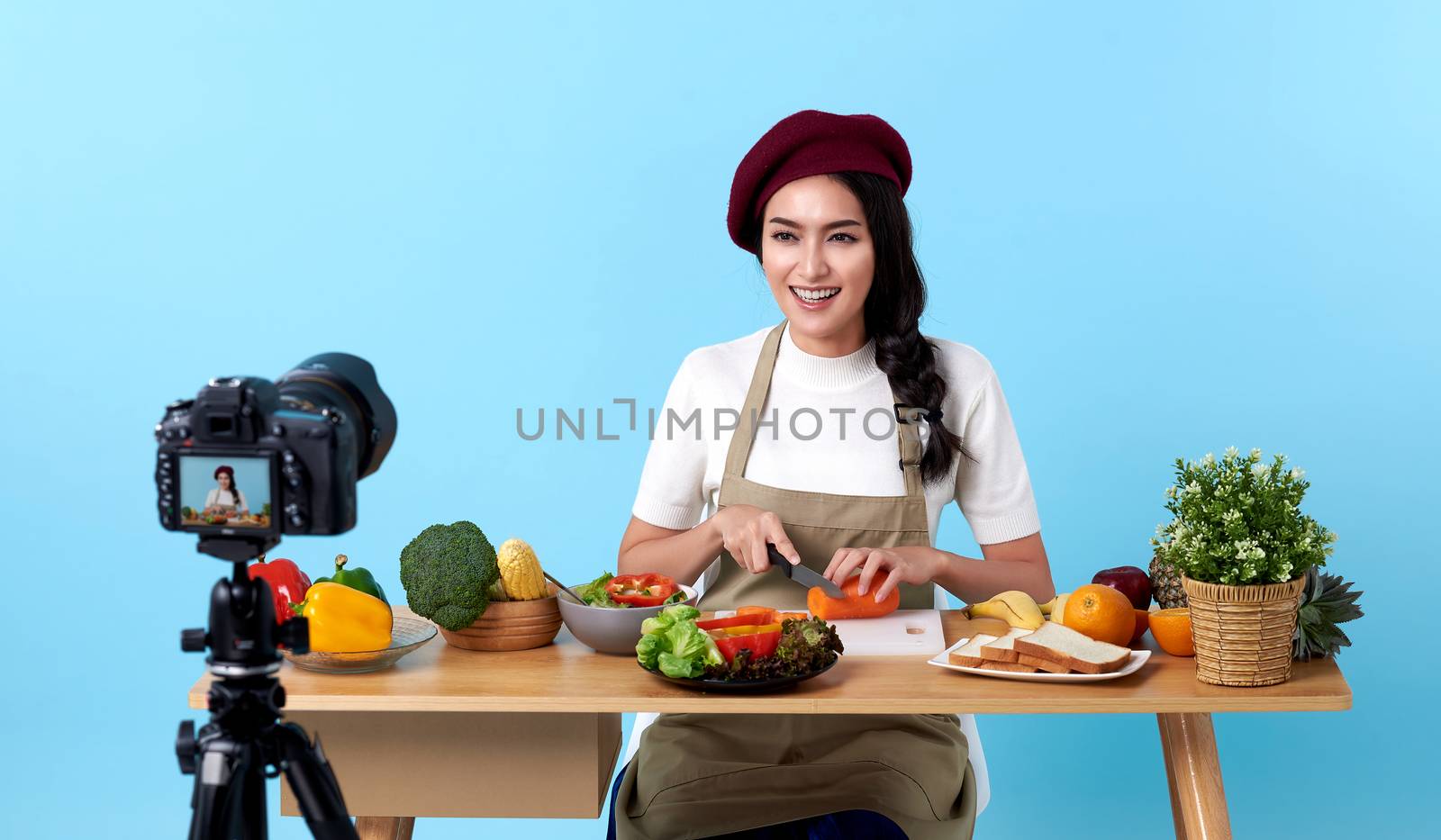 Happy asian young woman in fashion look style and shooting video with camera cooking food healthy is blogger presenting for social people.Her is influencer in social online.