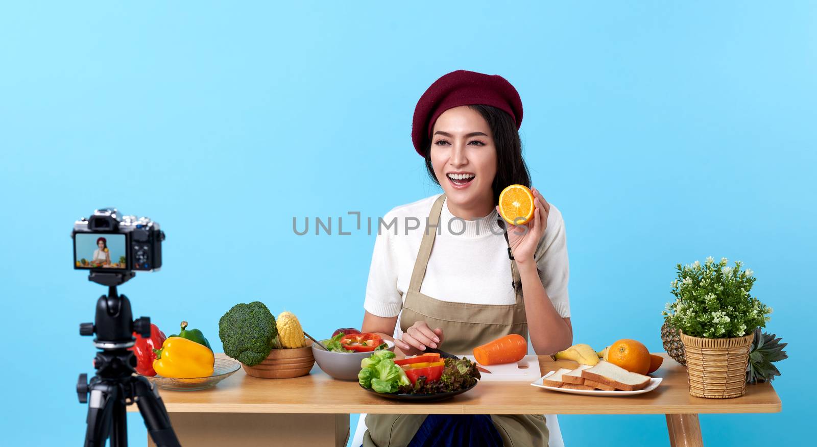 Happy asian young woman in fashion look style and shooting video with camera cooking food healthy is blogger presenting for social people.Her is influencer in social online. by barameeyay