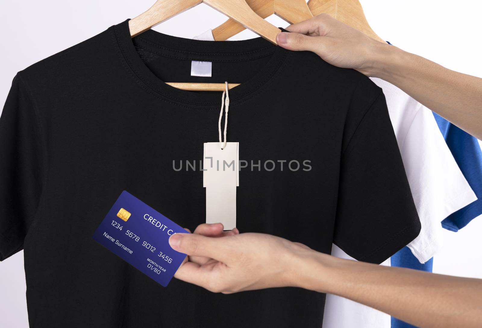 Mockup blank black t-shirt and blank label tag for advertising. Hand holding credit card for shopping for shirt.