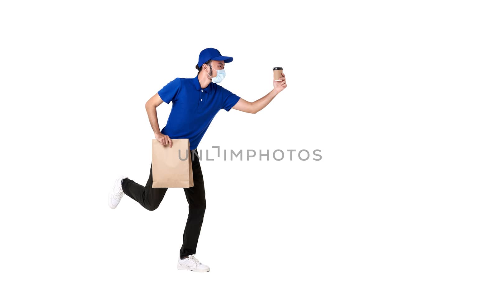 Asian delivery man wearing face mask in blue uniform running with paper bag and takeaway coffee isolated over white background. express delivery service during covid19.