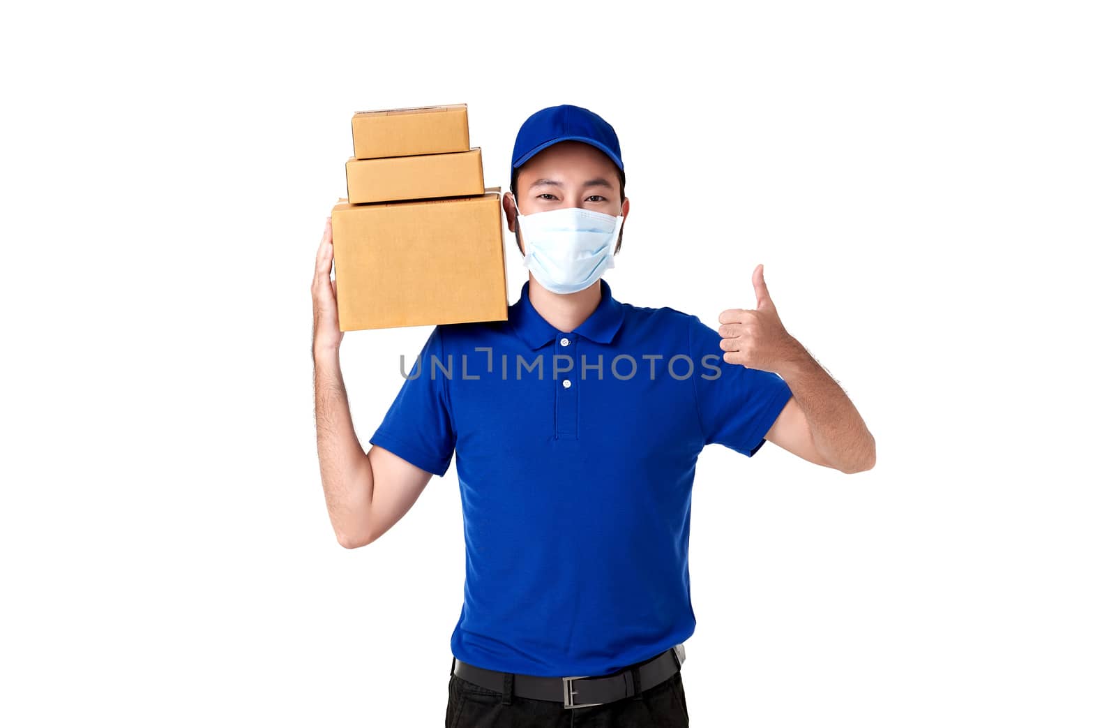 Asian delivery man wearing face mask in blue uniform standing with carry parcel post box isolated over white background. express delivery service during covid19. by barameeyay