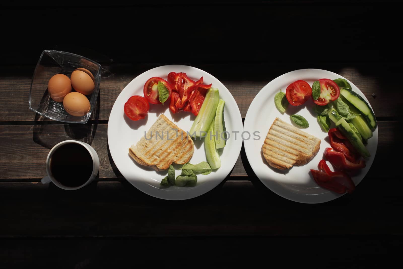 Healthy organic vegetable breakfast, tomato, toast, salad, basil, egg, coffee. Vegetarian healthy food in a white plate on a dark wooden table. High quality photo