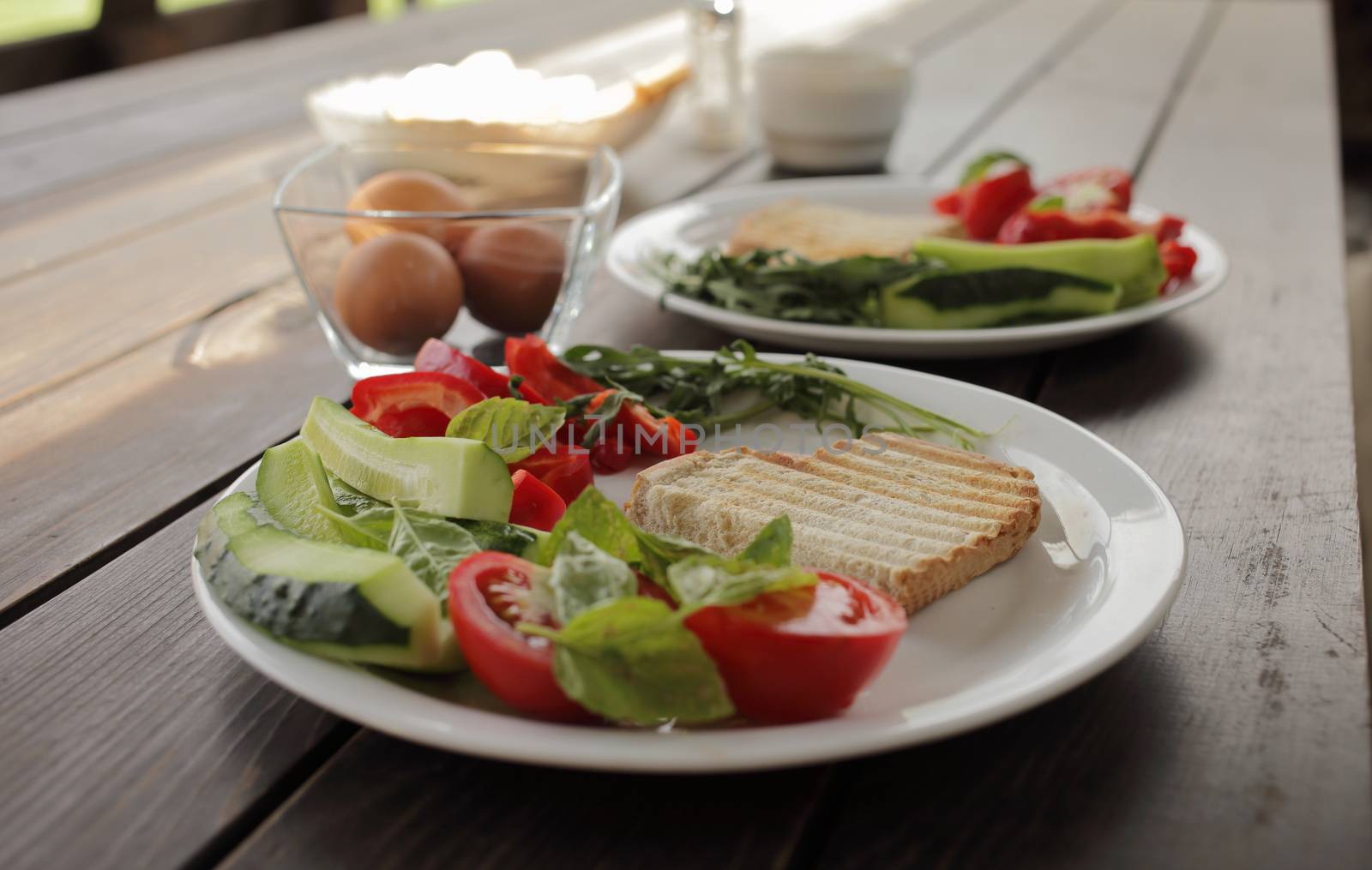 Healthy organic vegetable breakfast, tomato, toast, salad, basil, egg. Vegetarian healthy food in a white plate on a dark wooden table. High quality photo