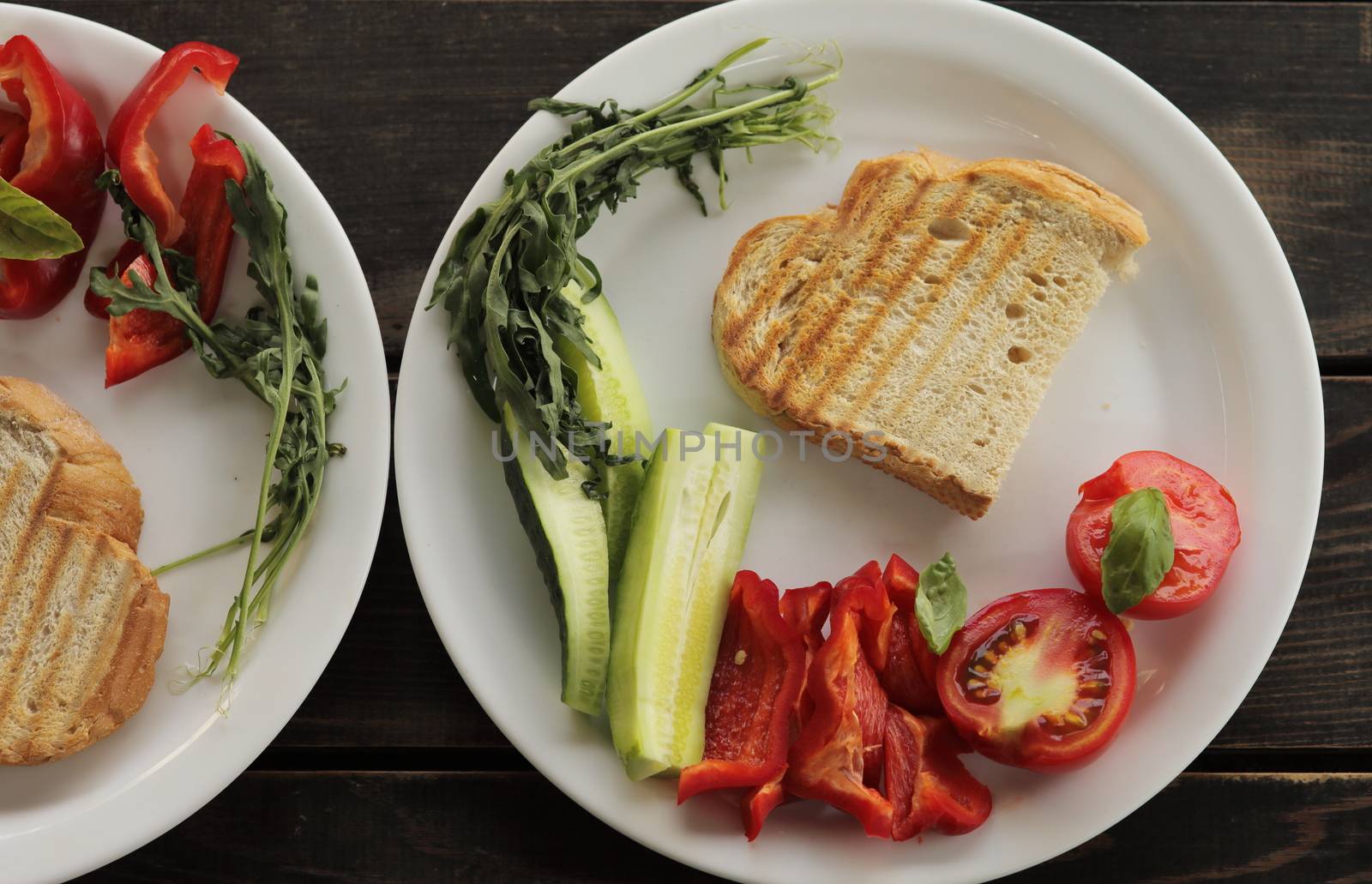 Healthy organic vegetable breakfast, tomato toast salad basil cucumber arugula by selinsmo