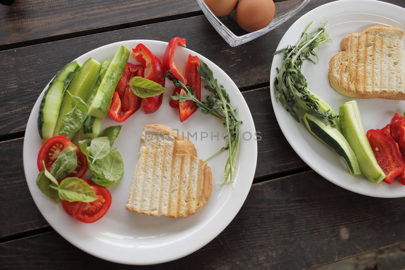 Healthy organic vegetable breakfast, tomato, toast, salad, basil, egg. Vegetarian healthy food in a white plate on a dark wooden table. High quality photo