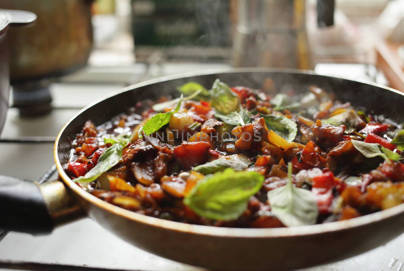 Healthy food, vegetables are fried in a pan. Tomato eggplant onion pepper zucchini basil. Steam
