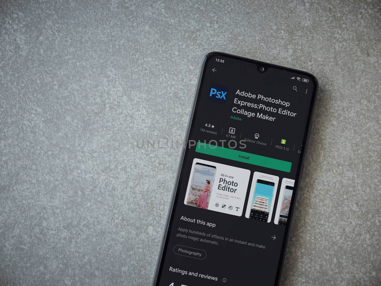 Lod, Israel - July 8, 2020: Adobe Photoshop Express Photo Editor app play store page on the display of a black mobile smartphone on ceramic stone background. Top view flat lay with copy space.