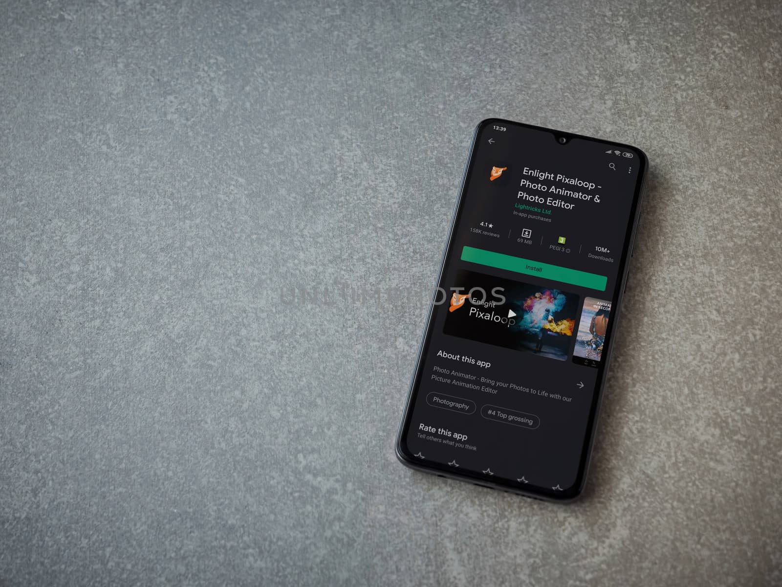 Lod, Israel - July 8, 2020: Enlight Pixaloop app play store page on the display of a black mobile smartphone on ceramic stone background. Top view flat lay with copy space.