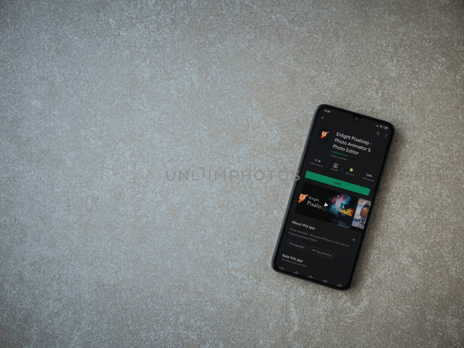 Lod, Israel - July 8, 2020: Enlight Pixaloop app play store page on the display of a black mobile smartphone on ceramic stone background. Top view flat lay with copy space.