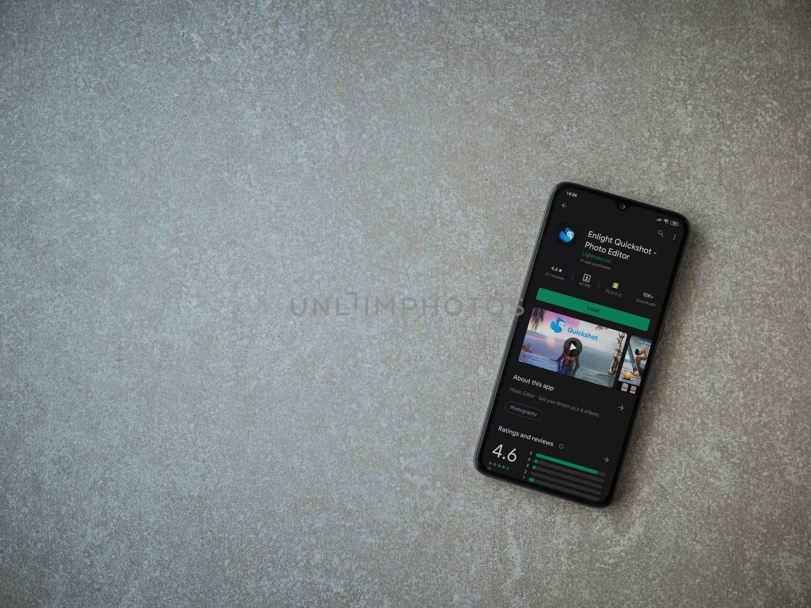Lod, Israel - July 8, 2020: Enlight Quickshot app play store page on the display of a black mobile smartphone on ceramic stone background. Top view flat lay with copy space.