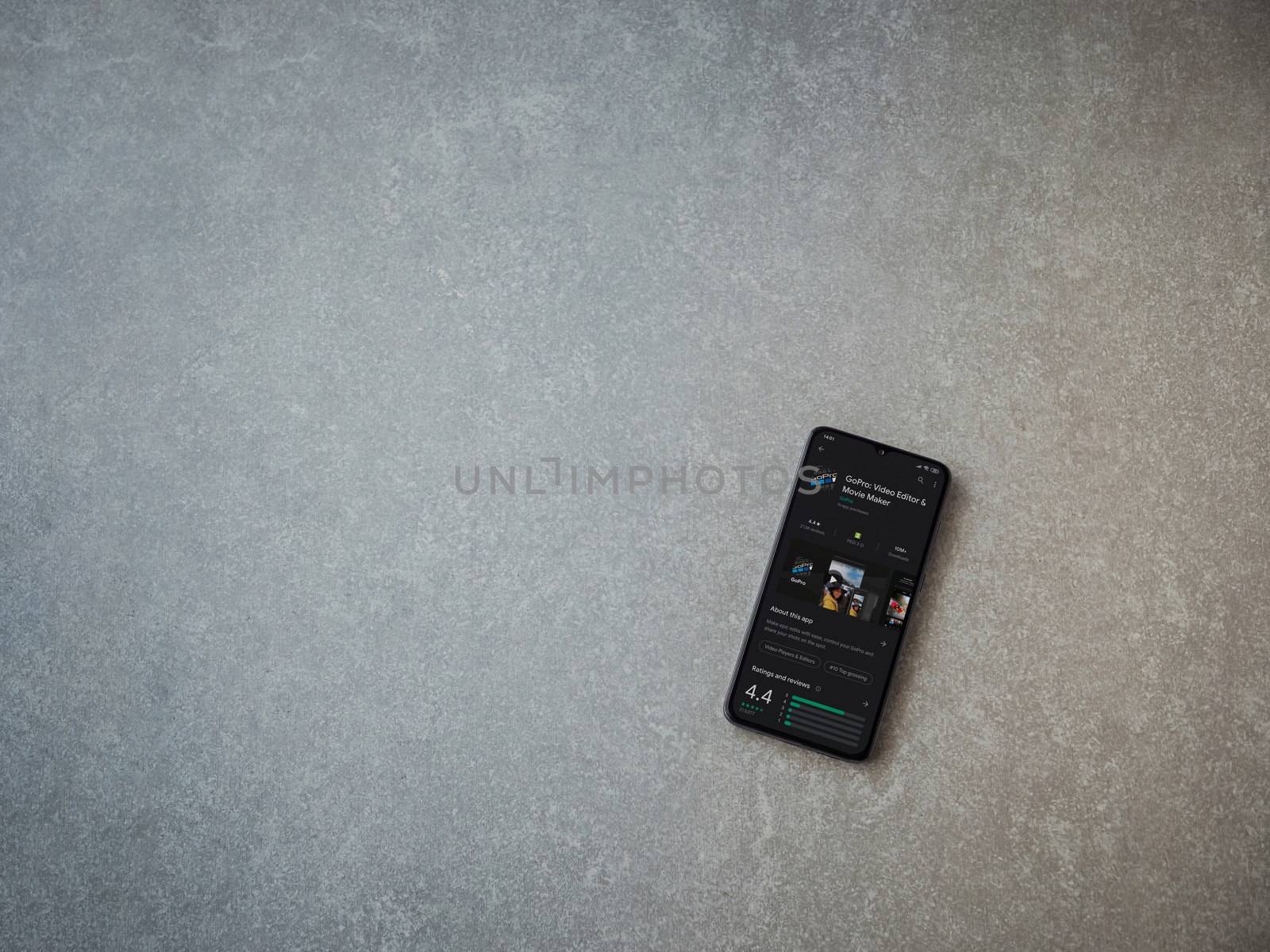 Lod, Israel - July 8, 2020: GoPro - Video Editor and Movie Maker app play store page on the display of a black mobile smartphone on ceramic stone background. Top view flat lay with copy space.