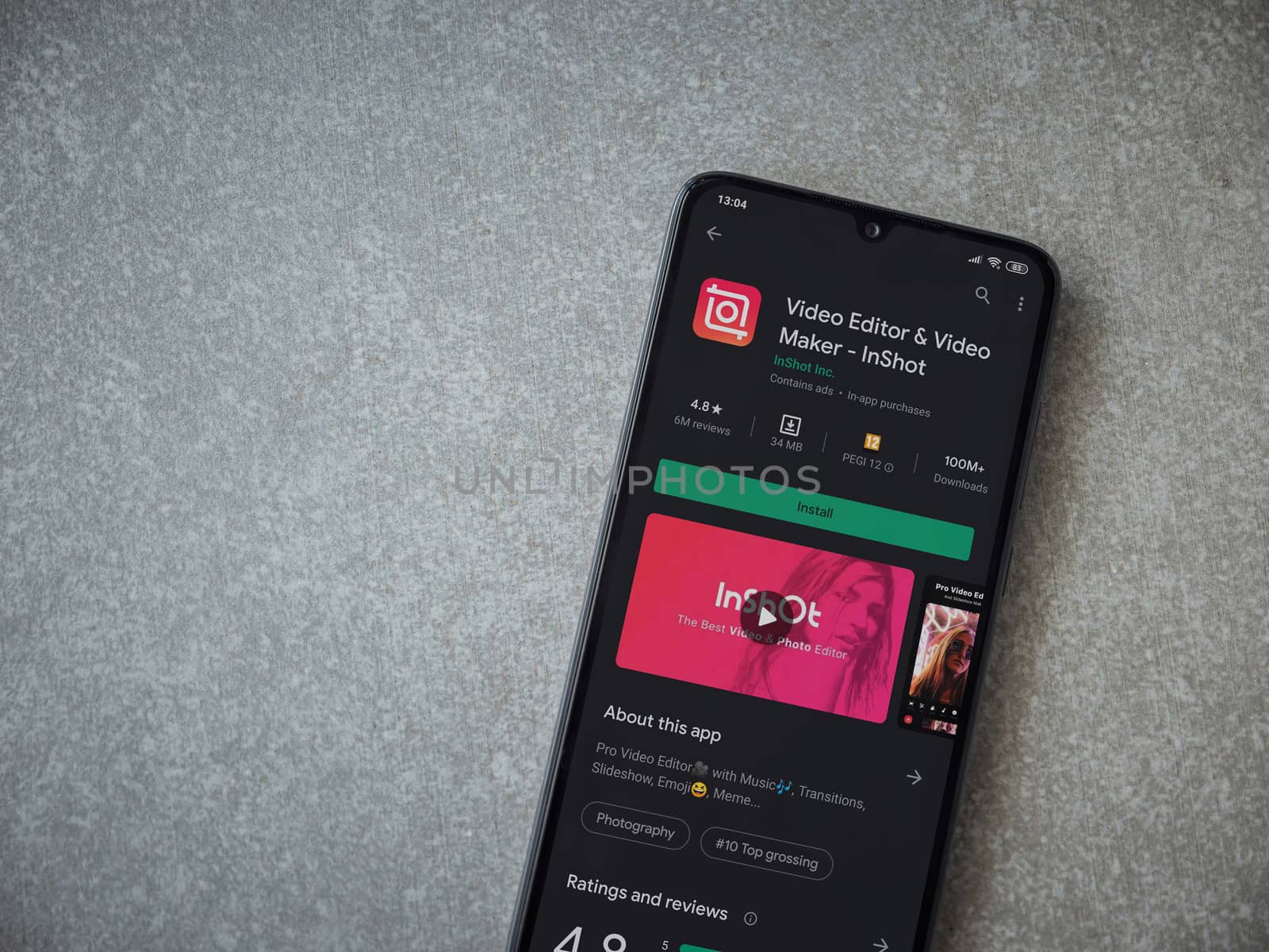 Lod, Israel - July 8, 2020: InShot - Video Editor and Movie Maker app play store page on the display of a black mobile smartphone on ceramic stone background. Top view flat lay with copy space.