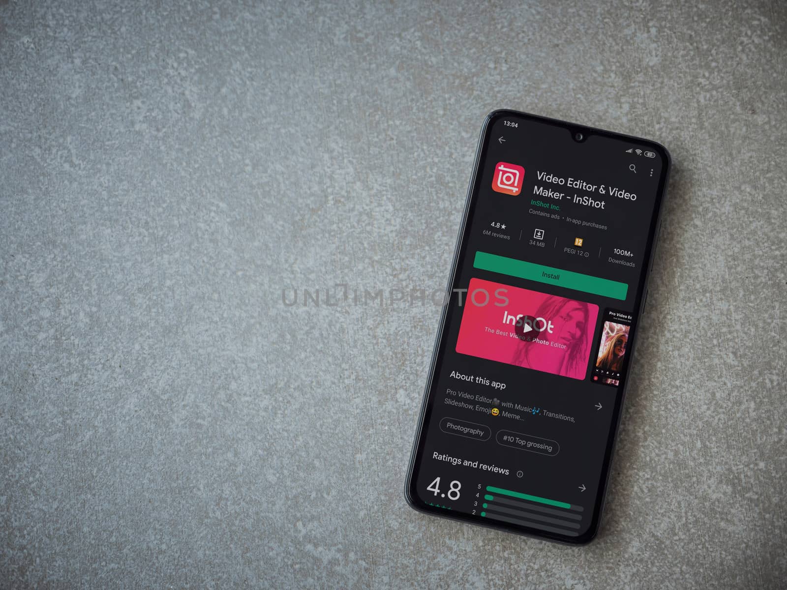 Lod, Israel - July 8, 2020: InShot - Video Editor and Movie Maker app play store page on the display of a black mobile smartphone on ceramic stone background. Top view flat lay with copy space.