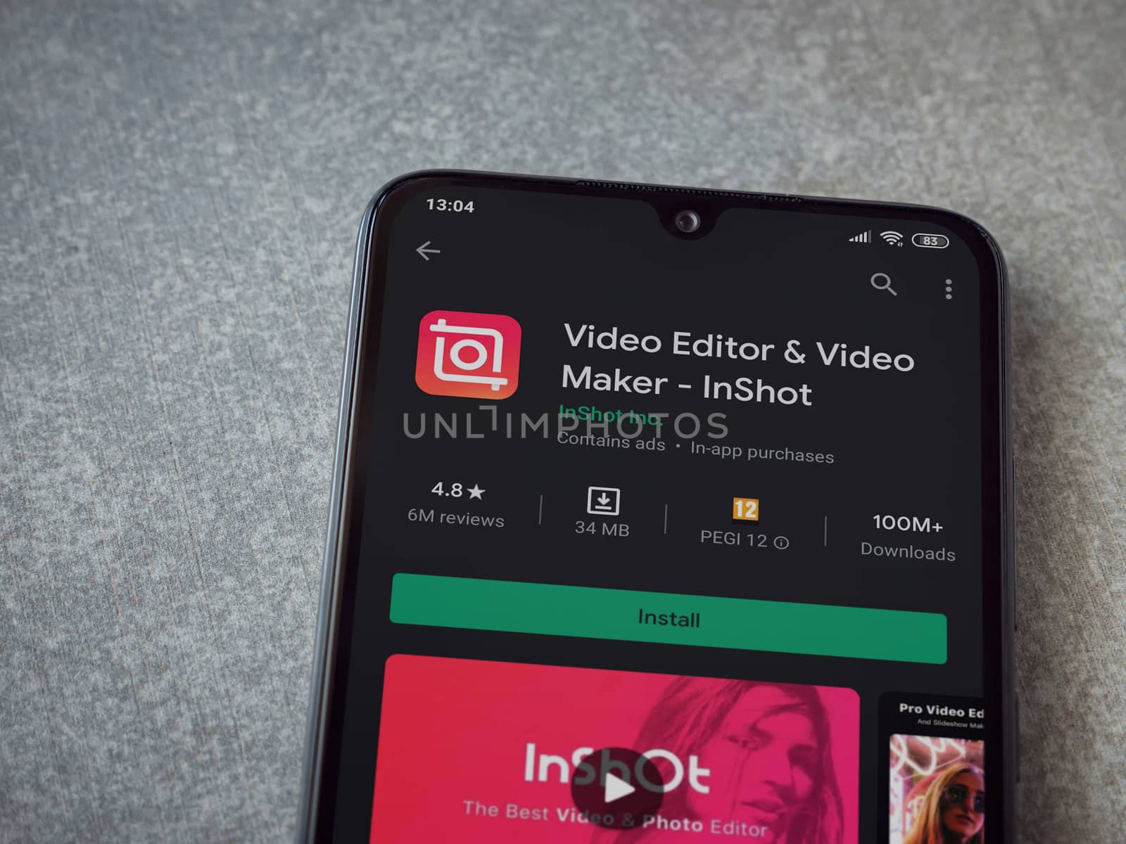 Lod, Israel - July 8, 2020: InShot - Video Editor and Movie Maker app play store page on the display of a black mobile smartphone on ceramic stone background. Top view flat lay with copy space.