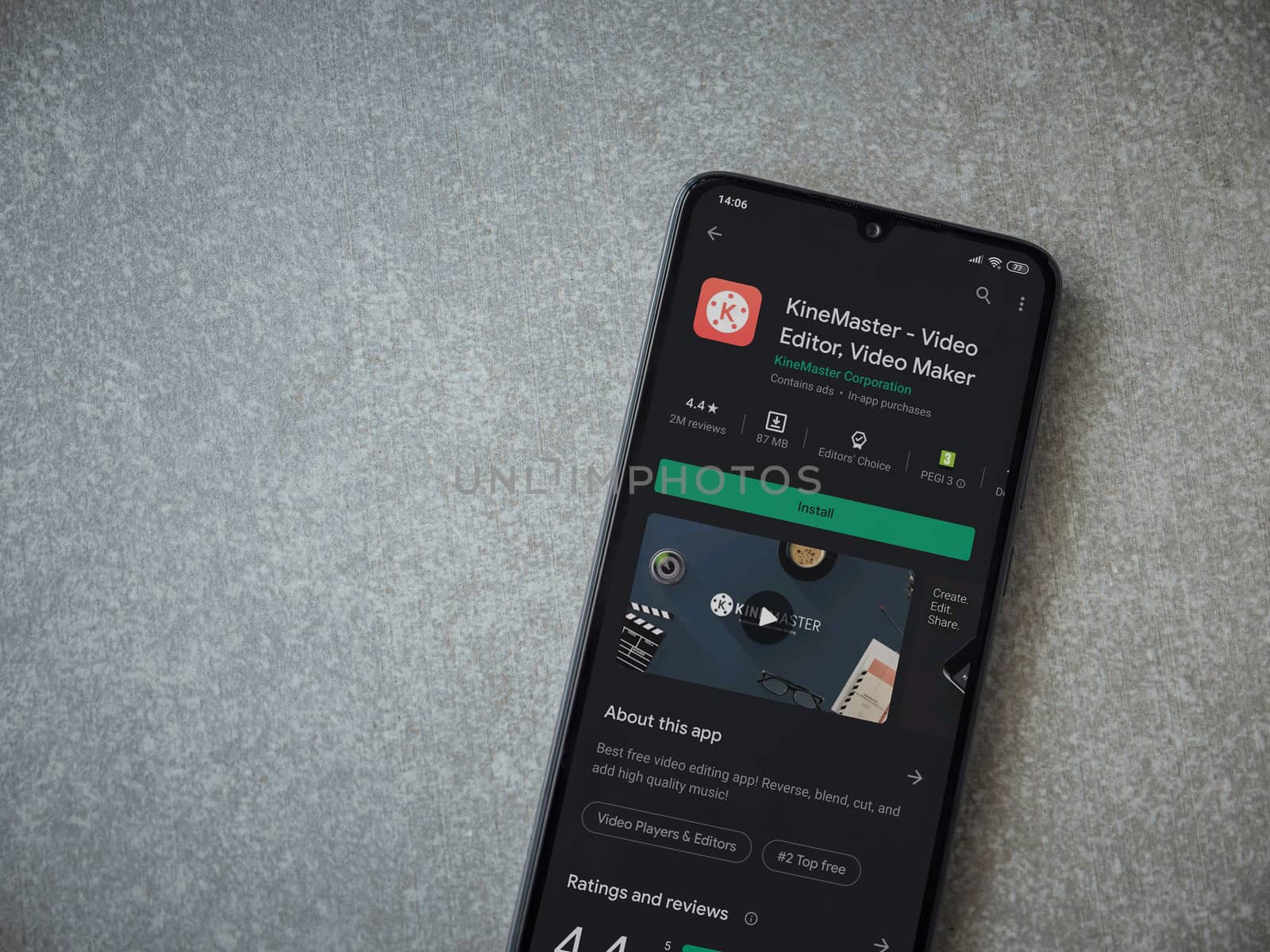 Lod, Israel - July 8, 2020: KineMaster - Video Editor and Movie Maker app play store page on the display of a black mobile smartphone on ceramic stone background. Top view flat lay with copy space.