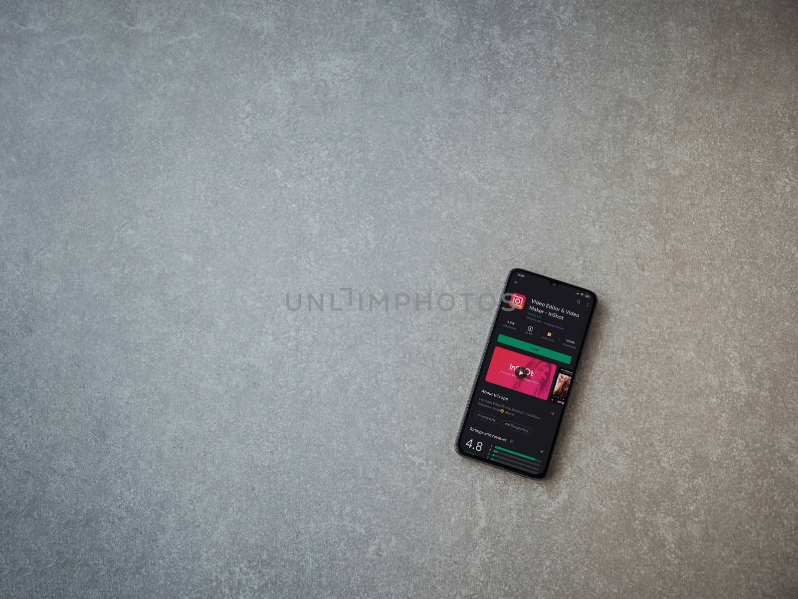 Lod, Israel - July 8, 2020: InShot - Video Editor and Movie Maker app play store page on the display of a black mobile smartphone on ceramic stone background. Top view flat lay with copy space.