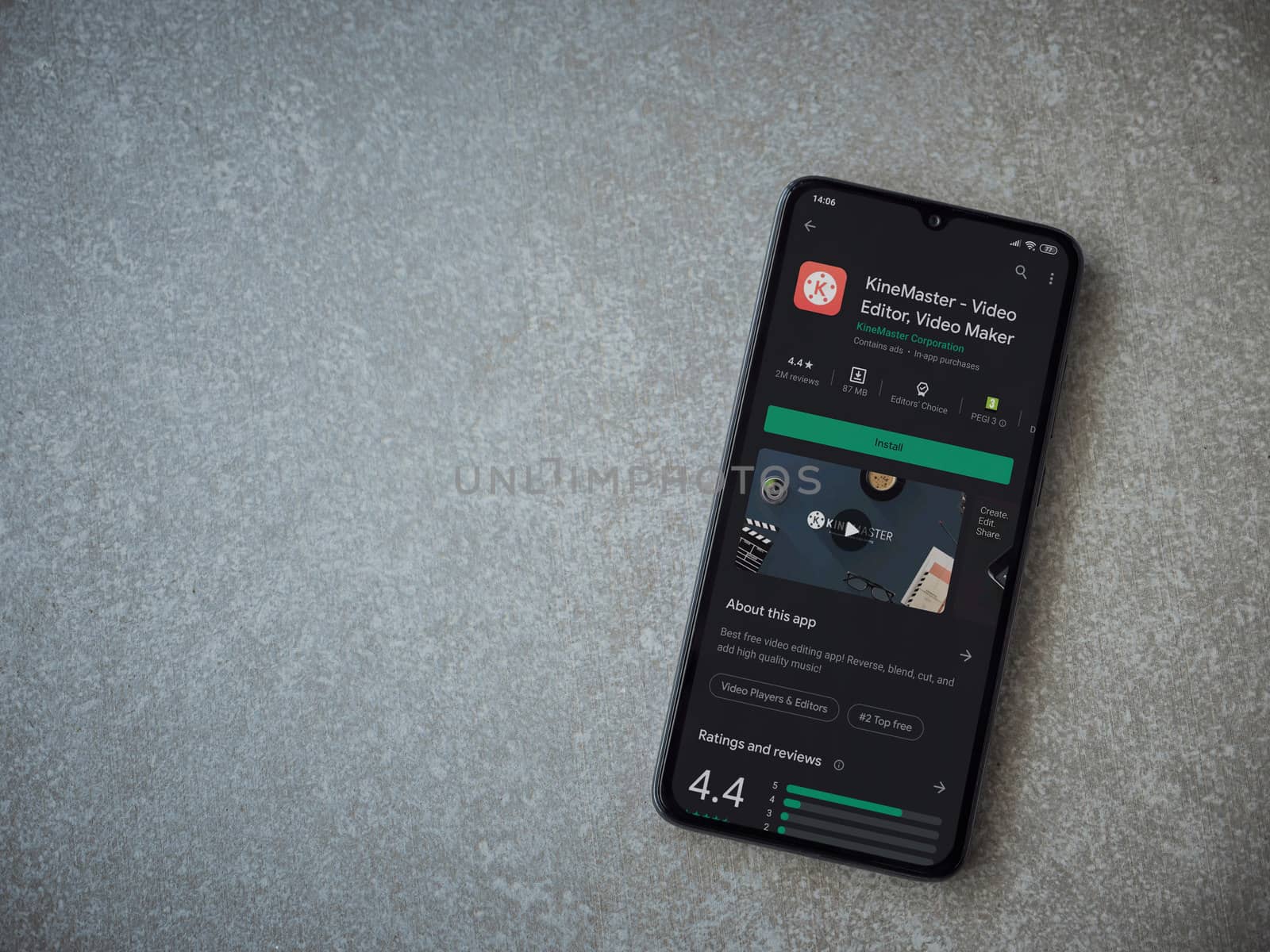 Lod, Israel - July 8, 2020: KineMaster - Video Editor and Movie Maker app play store page on the display of a black mobile smartphone on ceramic stone background. Top view flat lay with copy space.