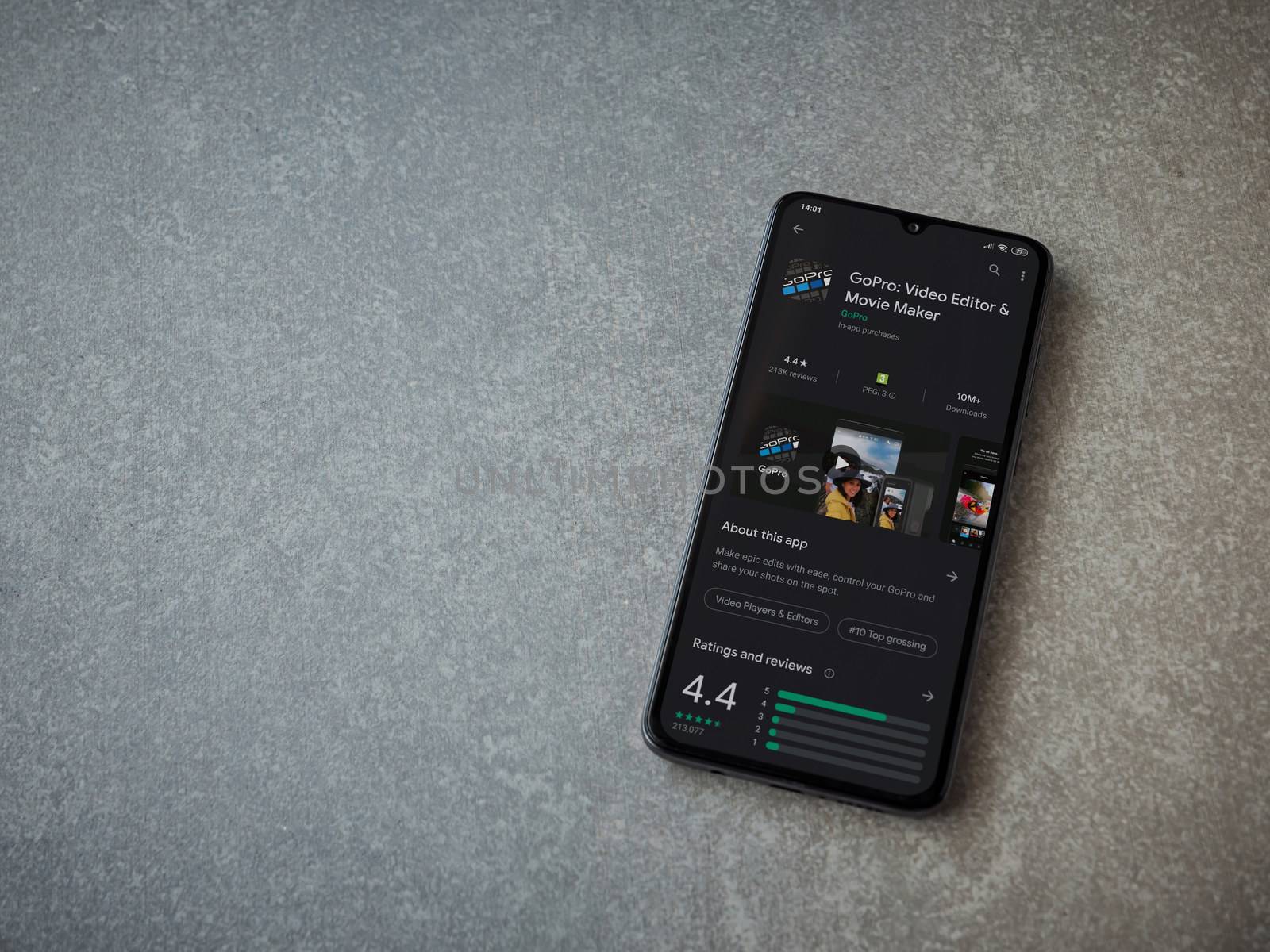 Lod, Israel - July 8, 2020: GoPro - Video Editor and Movie Maker app play store page on the display of a black mobile smartphone on ceramic stone background. Top view flat lay with copy space.